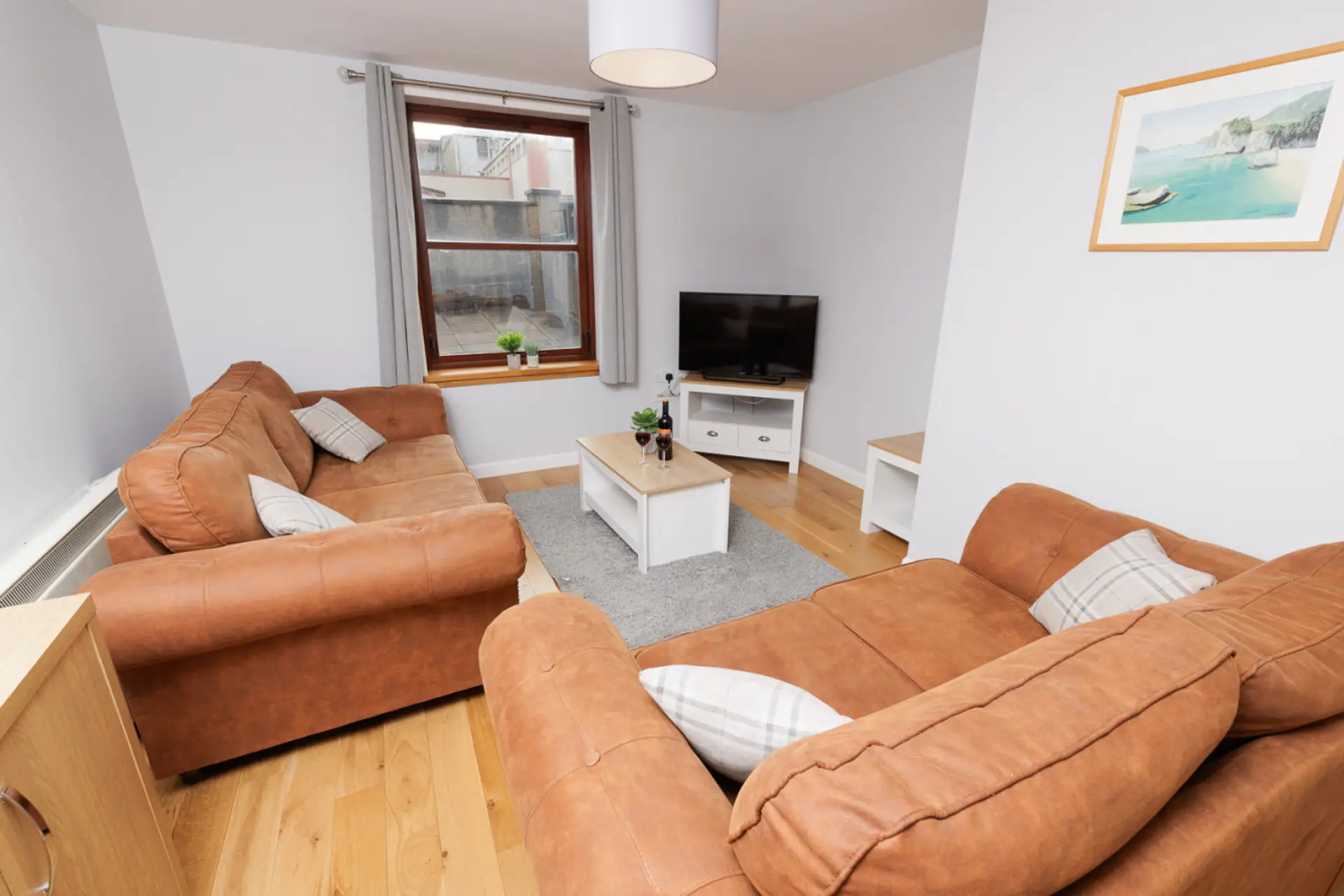 Cosy and light living area with TV and large sofas