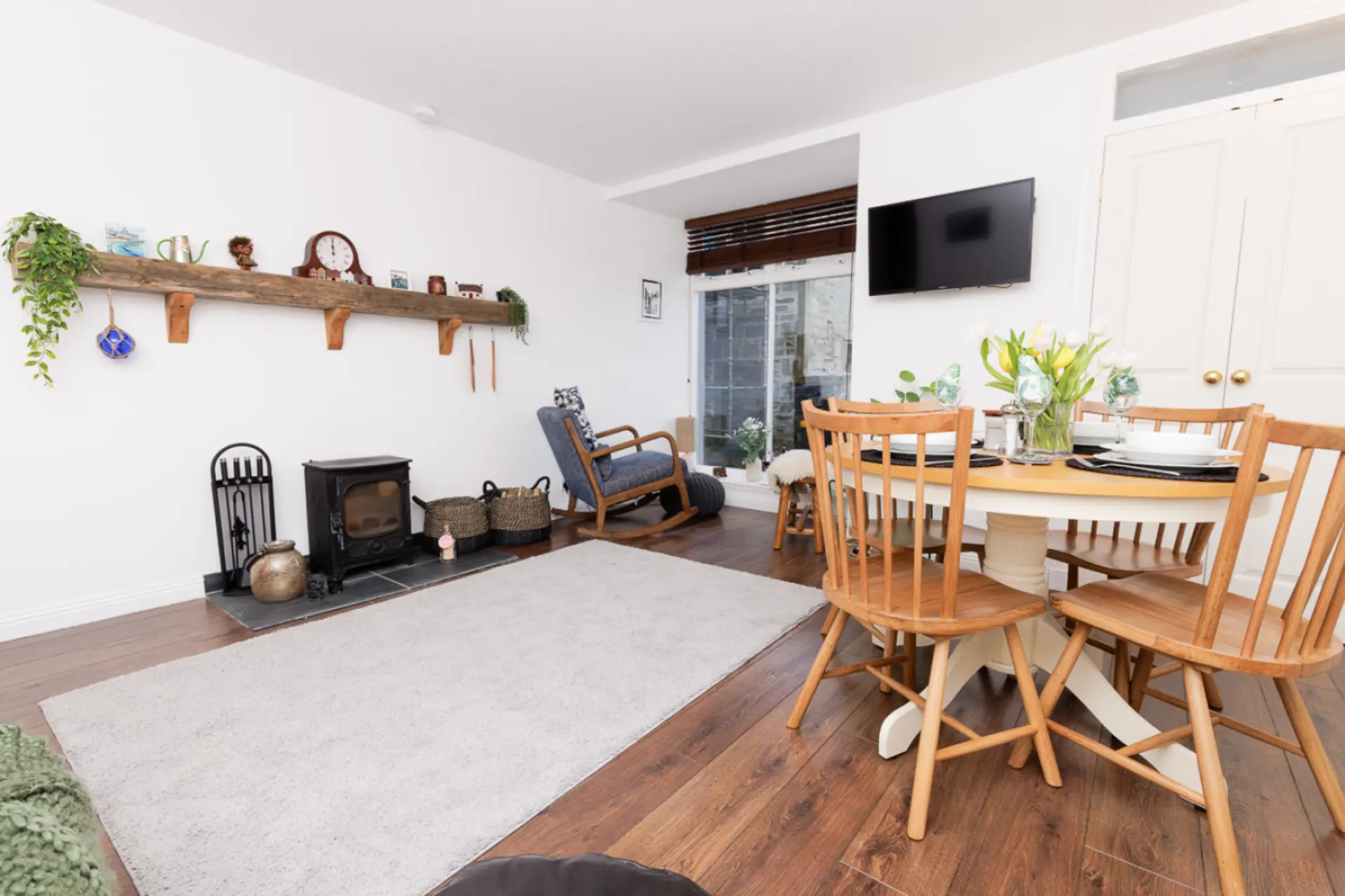 Living and dining area with log burner and wall-mounted TV
