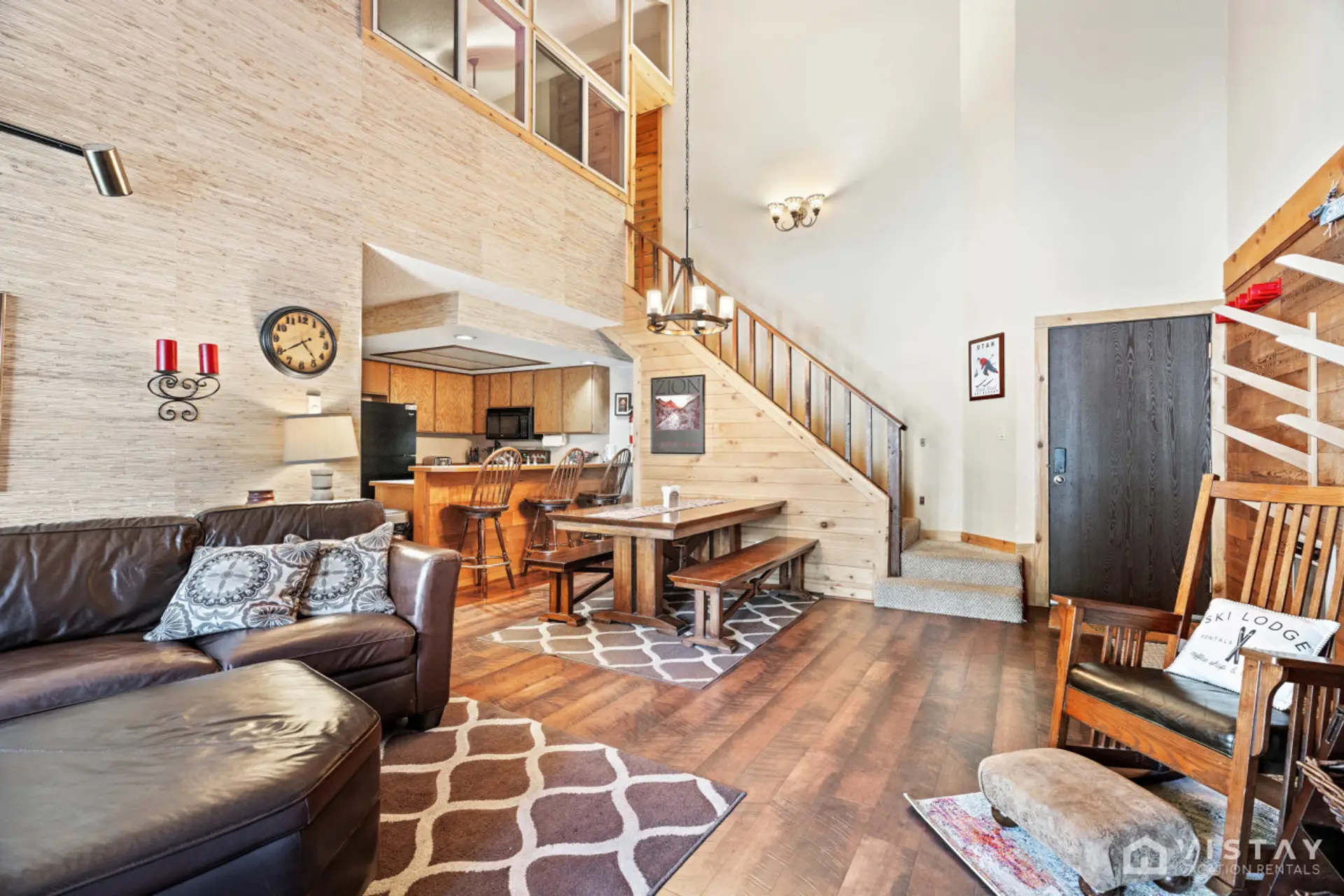Unwind in the spacious living room, featuring a huge curved sofa, a TV, a wood-burning fireplace, and a rocking chair, creating the perfect atmosphere for relaxation and entertainment.