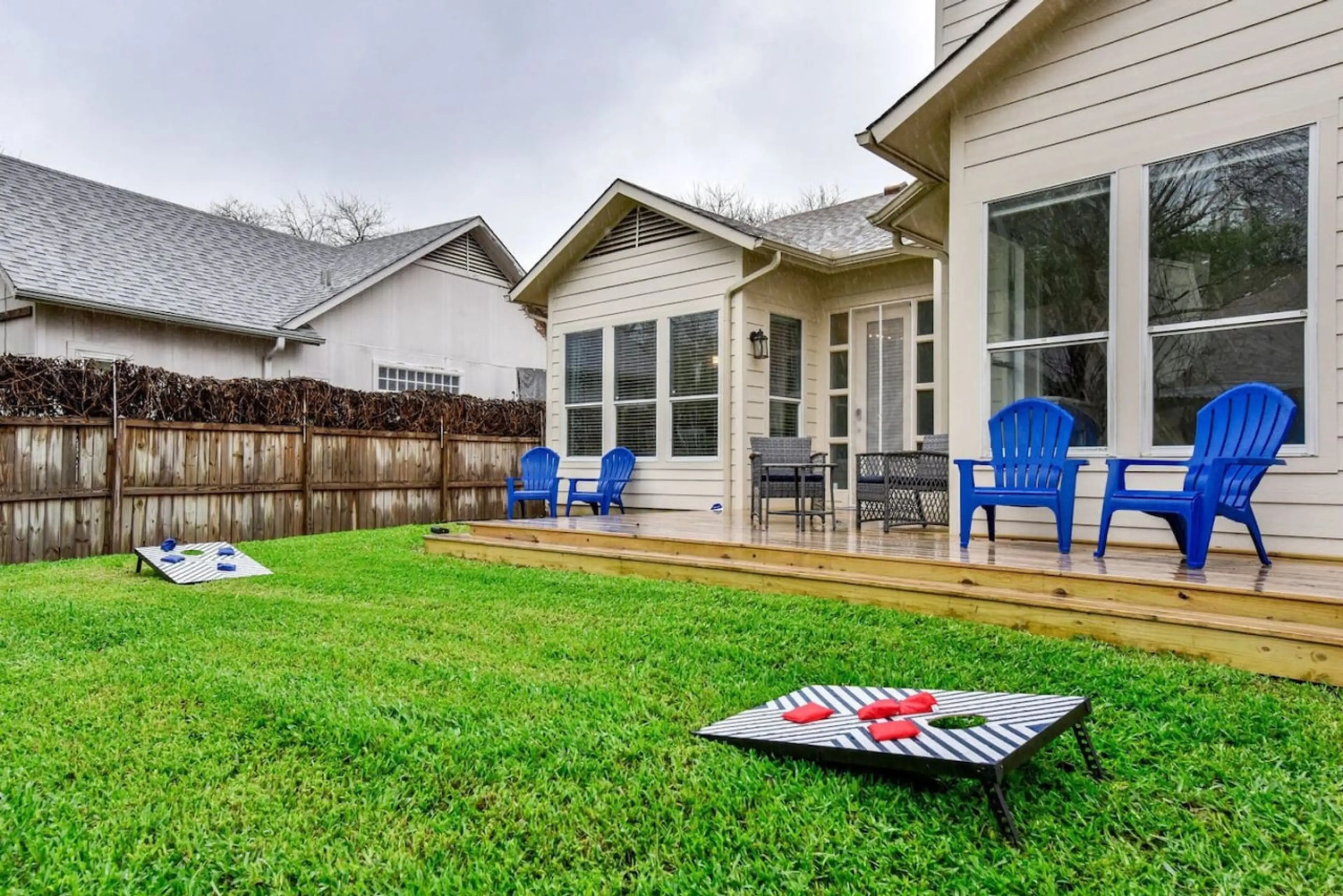 Enjoy lush green grass, outdoor seating, and a game of cornhole in the backyard.