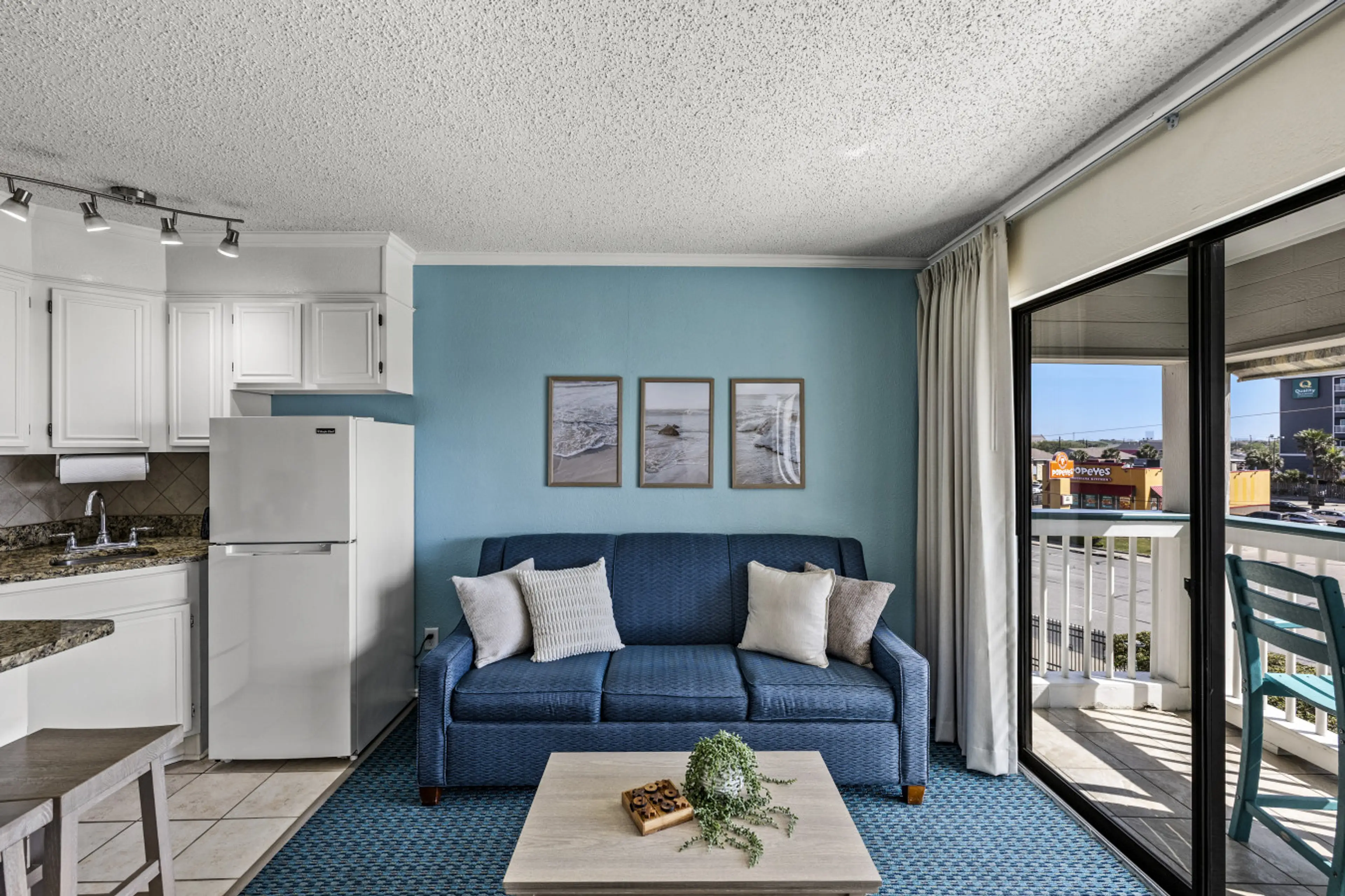 Bright, coastal living space with open kitchen and balcony access—designed for easy, comfortable beachside living.