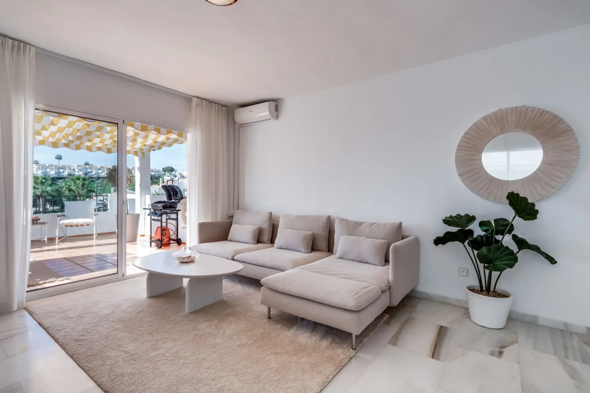 - Bright coastal living room with sofa and AC near terrace - Open plan lounge with natural light and modern decor - Perfect vacation rental space for relaxing stays by the coast