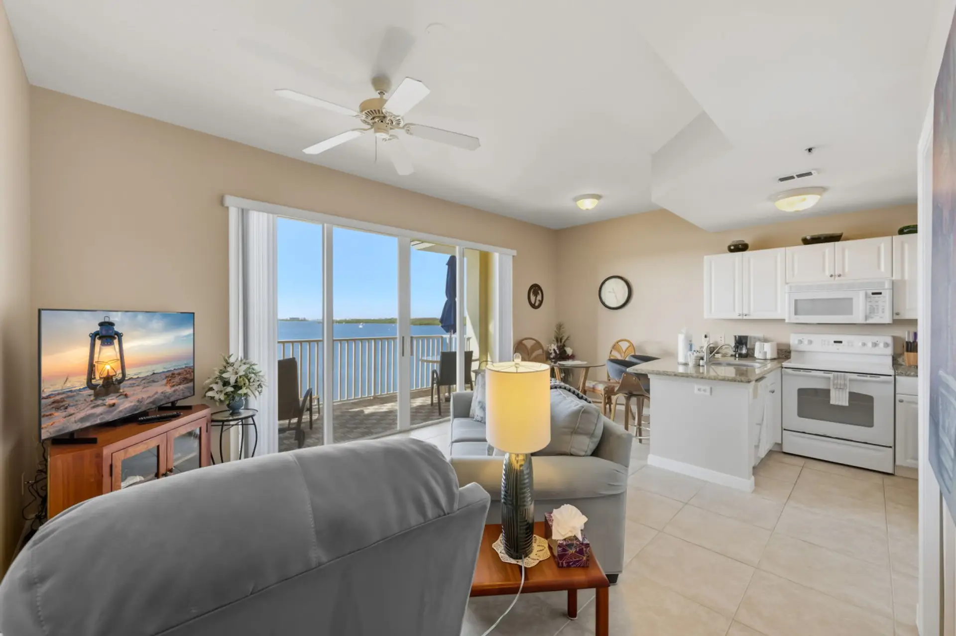 Bright, airy living room with large windows facing the bay, comfortable seating, and calming coastal decor