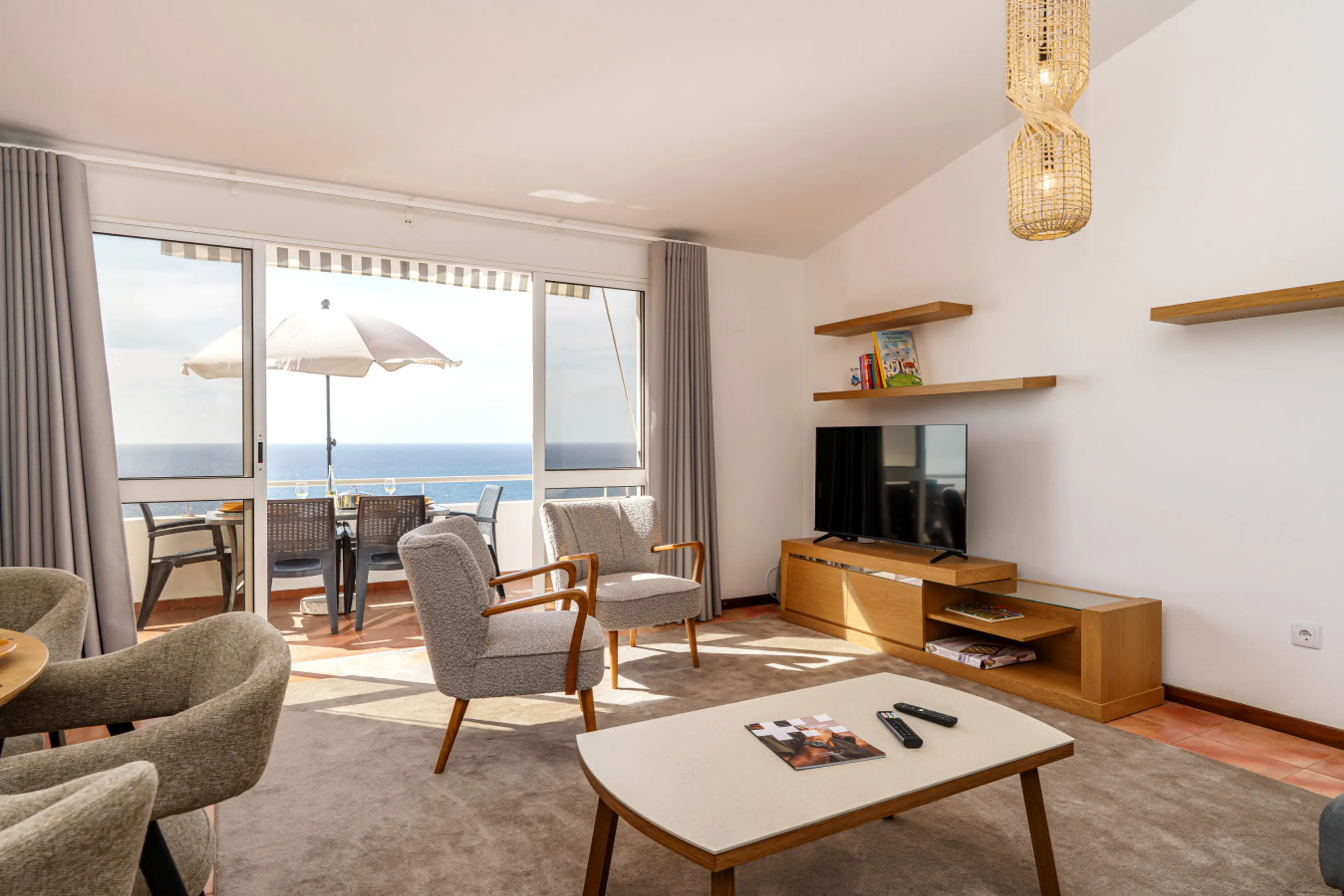 Discover a welcoming living space that opens to a terrace framed by the Atlantic on Madeira Island.