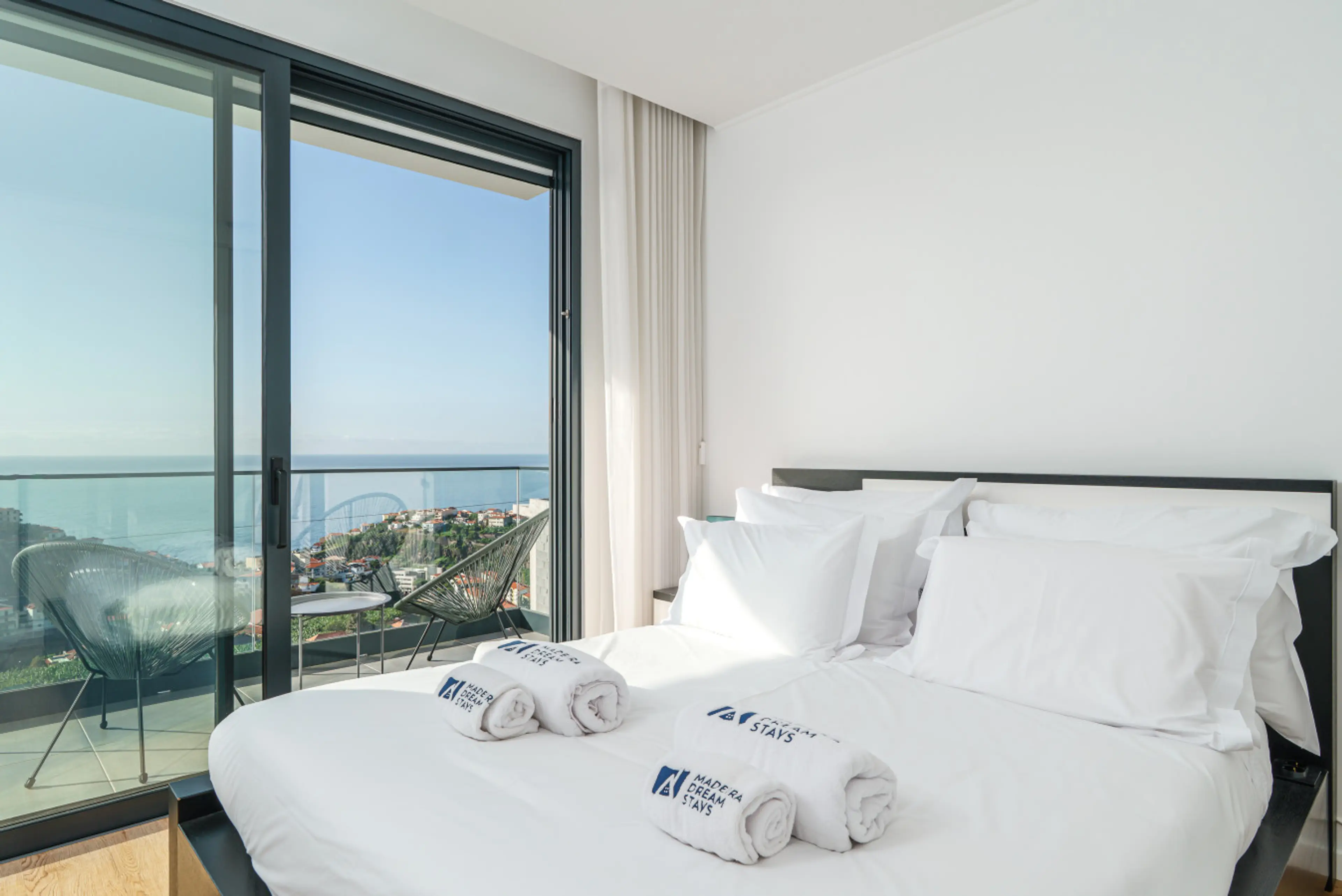 Experience a calm bedroom retreat framed by soft light and wide Madeira Island sea views.