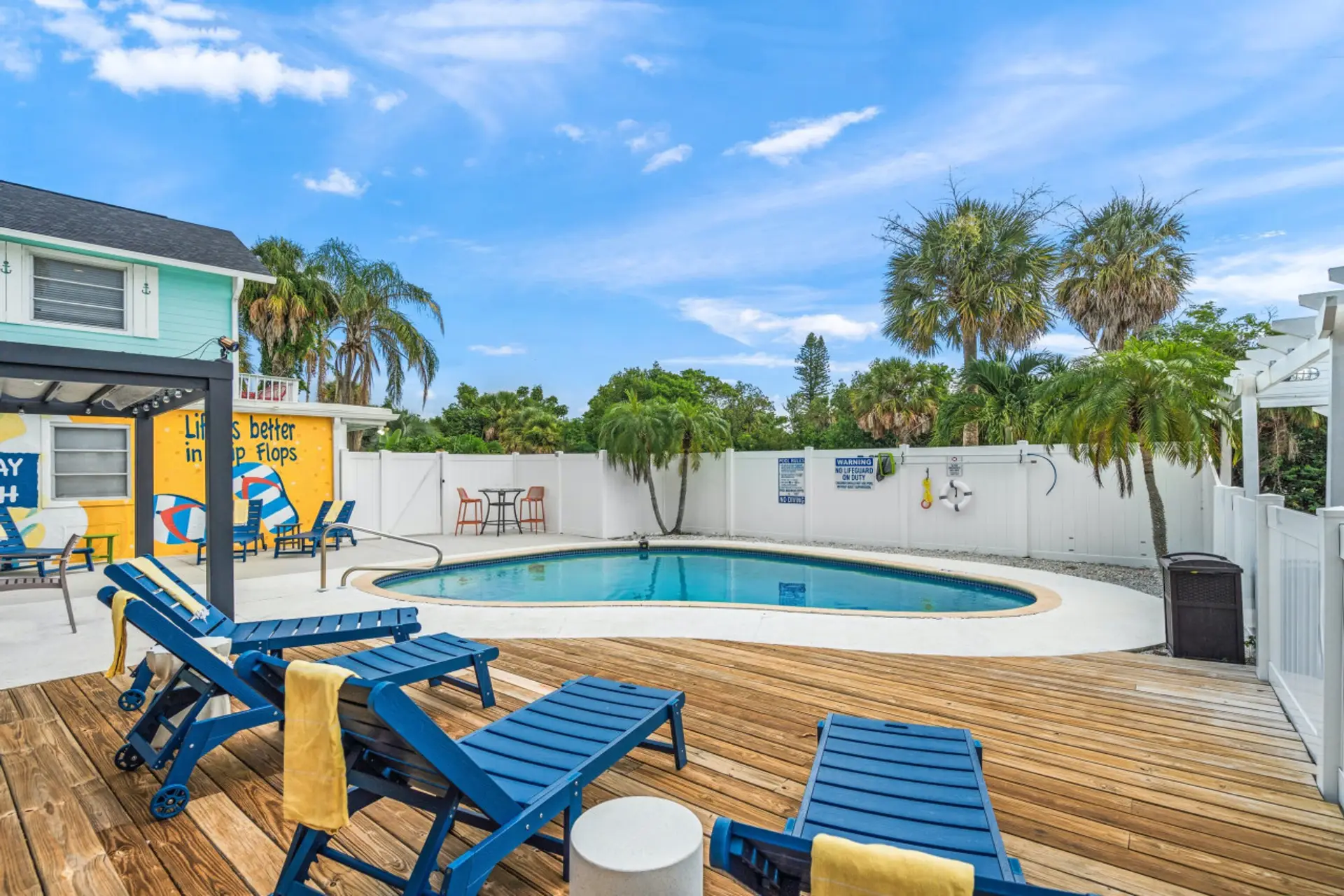 Siesta Key beach retreat with a mural-lined pool and pergola shade—styled for relaxed swims and laid-back coastal living.