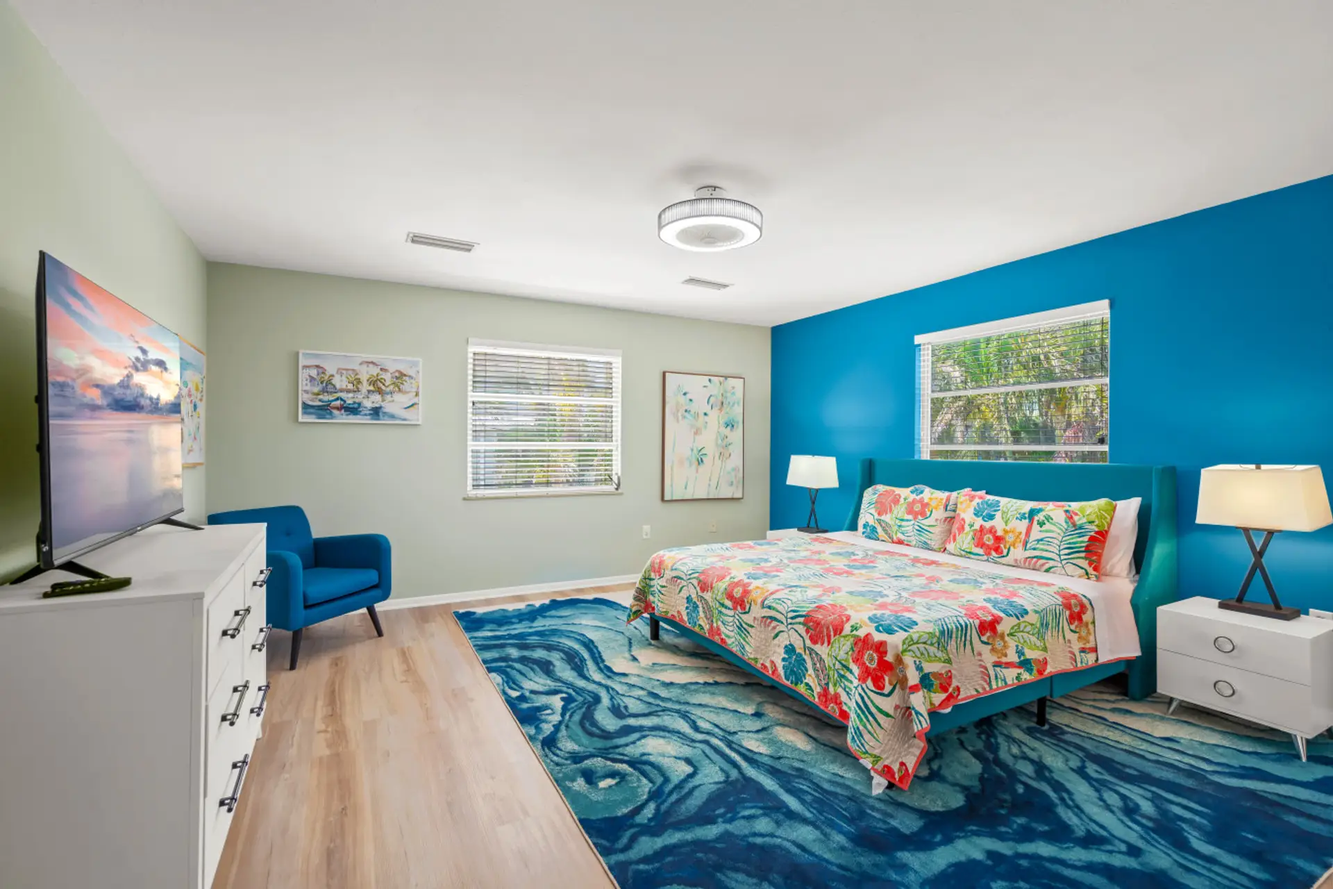 The Master Bedroom Suite at Siesta Key Retreat features soothing blue décor and large windows that fill the space with natural light