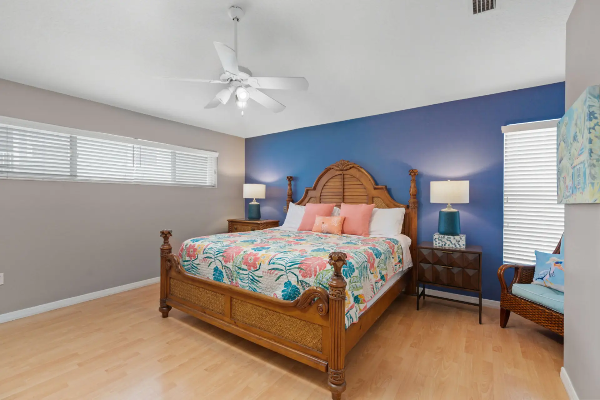 Siesta Key master retreat featuring a comfortable queen bed, tropical quilts, and a striking blue accent wall—an inviting, stylish sanctuary for a restful night after the beach.