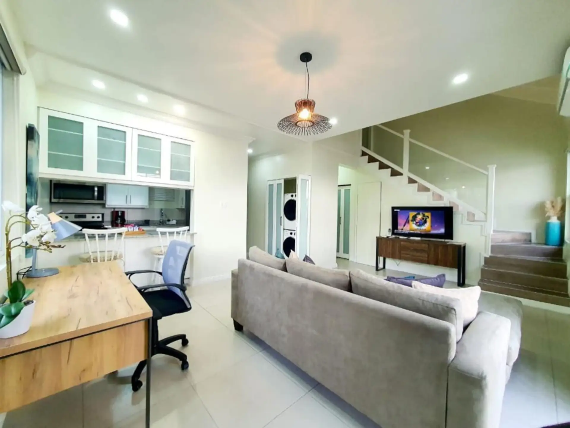 Open living area w/ sofa seating, TV & staircase leading up to the loft