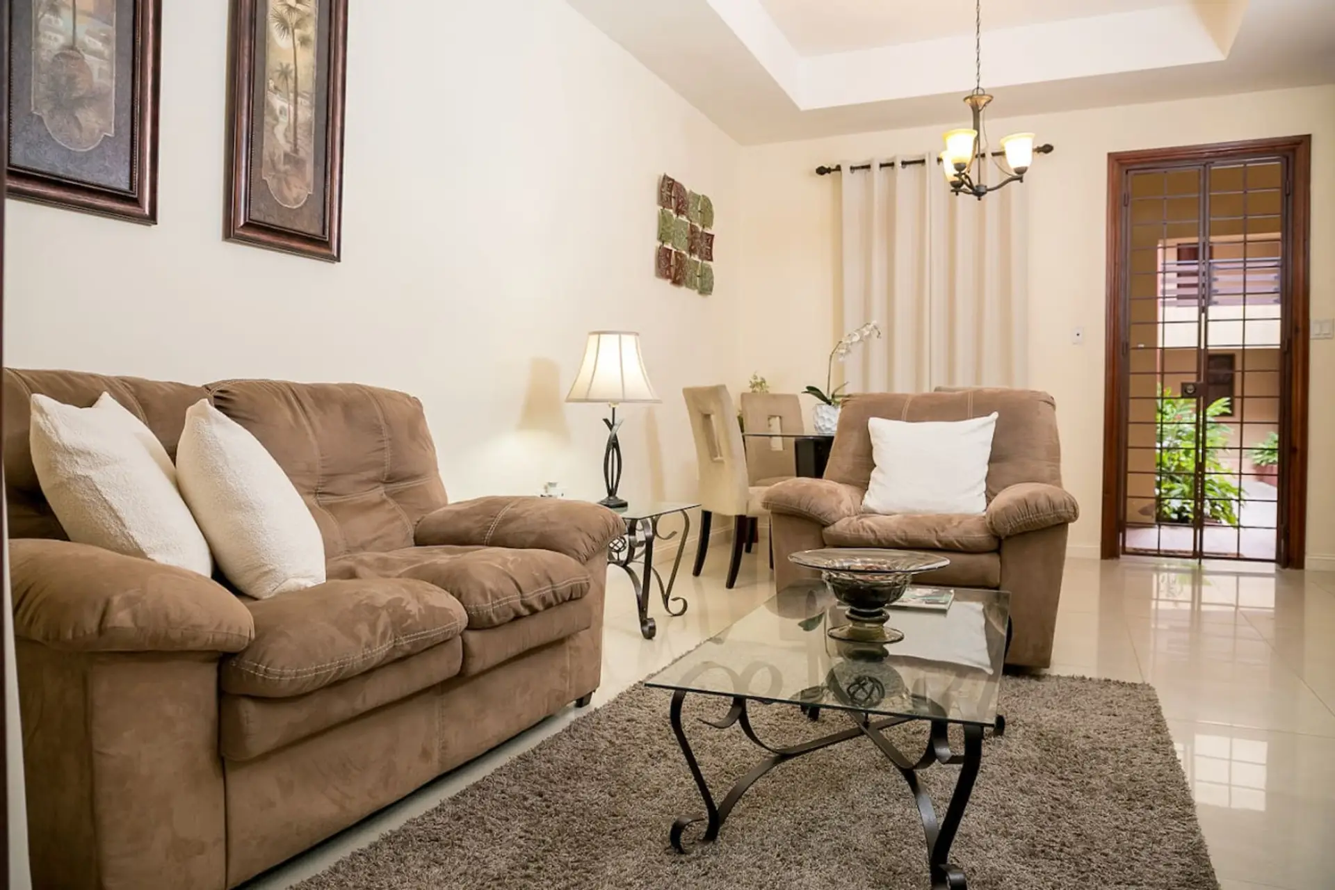 Cozy living room w/ plush sofas & glass coffee table, a comfy spot to relax after a day out.