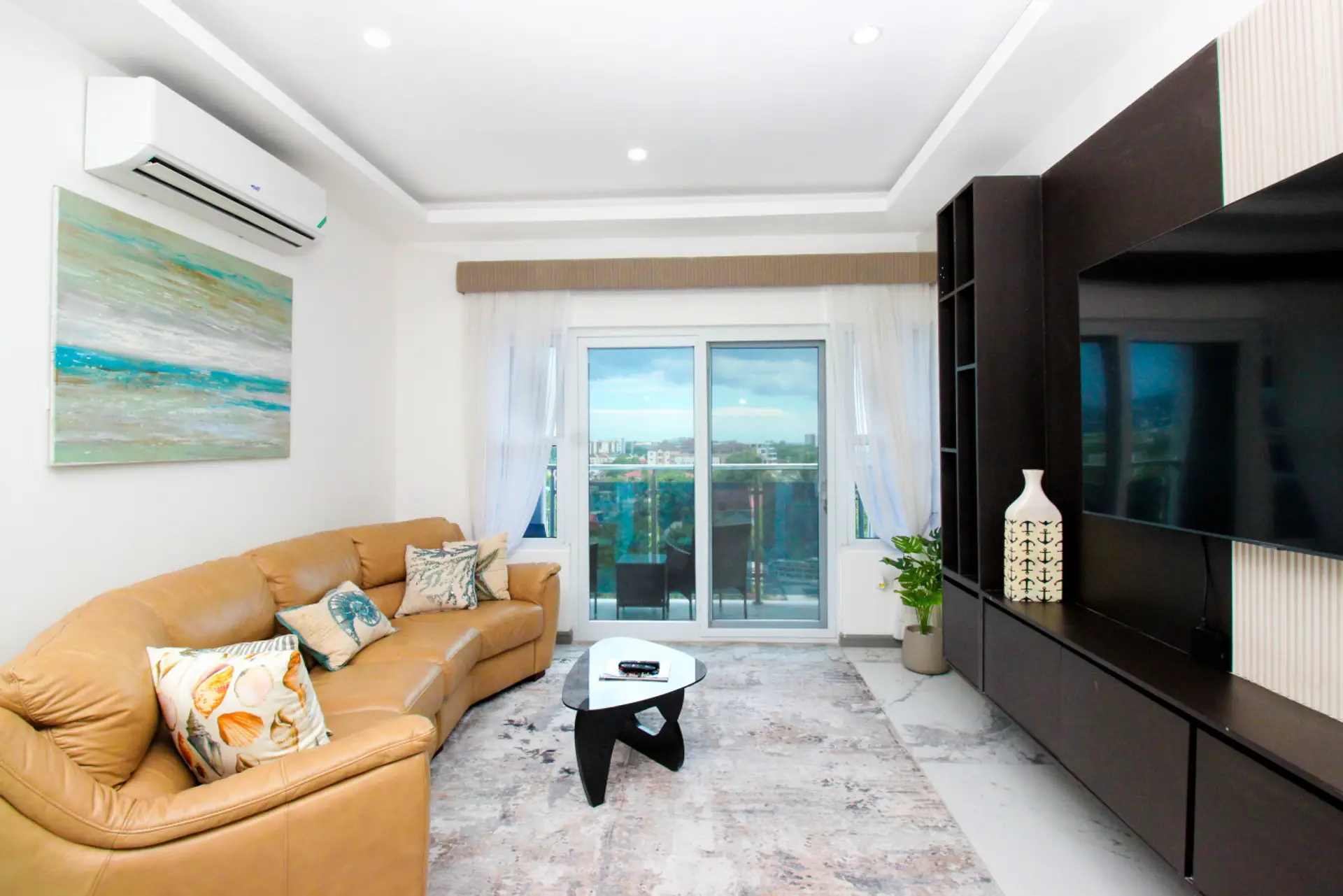Cozy living area w/ plush sofa, large TV & sliding doors bringing in natural light