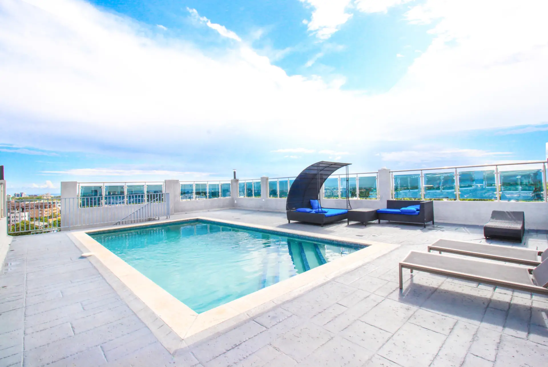 Sunlit pool deck w/ lounge chairs & open sky views, perfect for a refreshing dip or laid-back afternoon