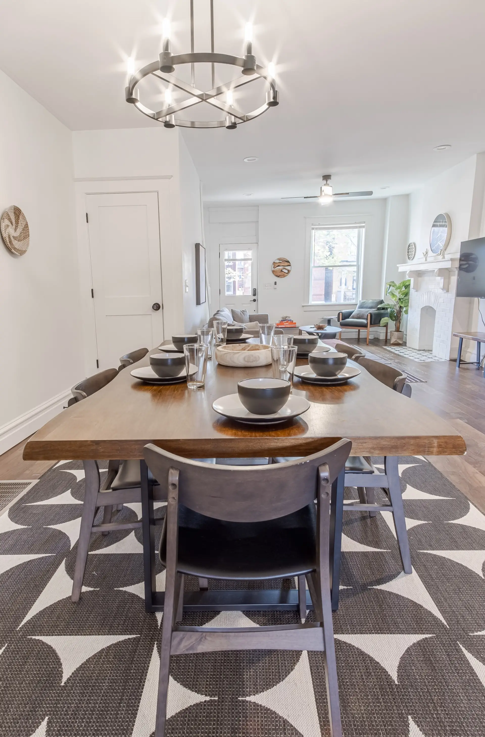 Enjoy meals at the spacious dining table with seating for six. The table is beautifully set with full dinnerware and cutlery, offering a warm and welcoming space to dine together.