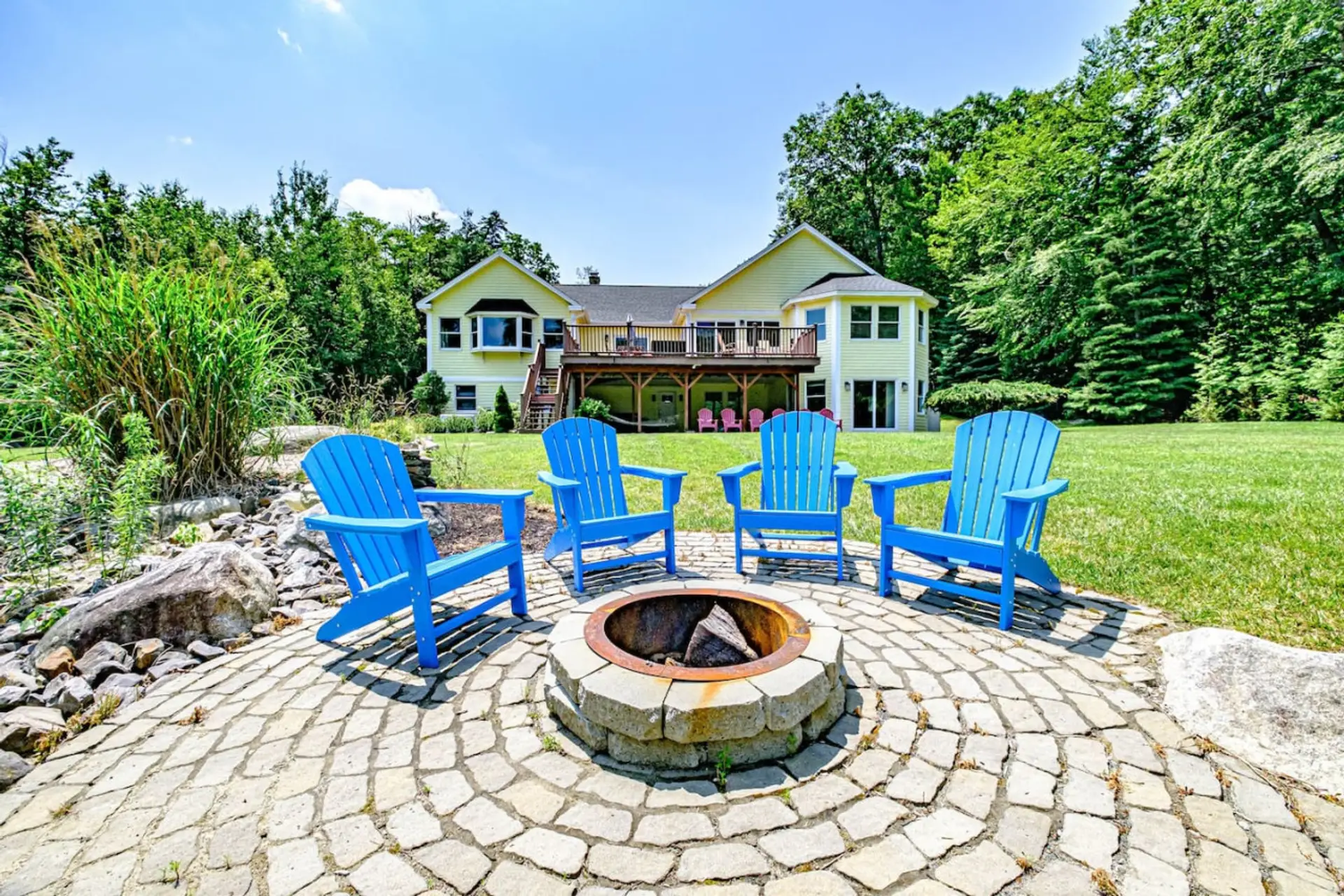 Exterior Backyard | Seating surrounding fire pit, kayaks, SUP, hammock. Upper deck has gas grill and dining set with additional seating.