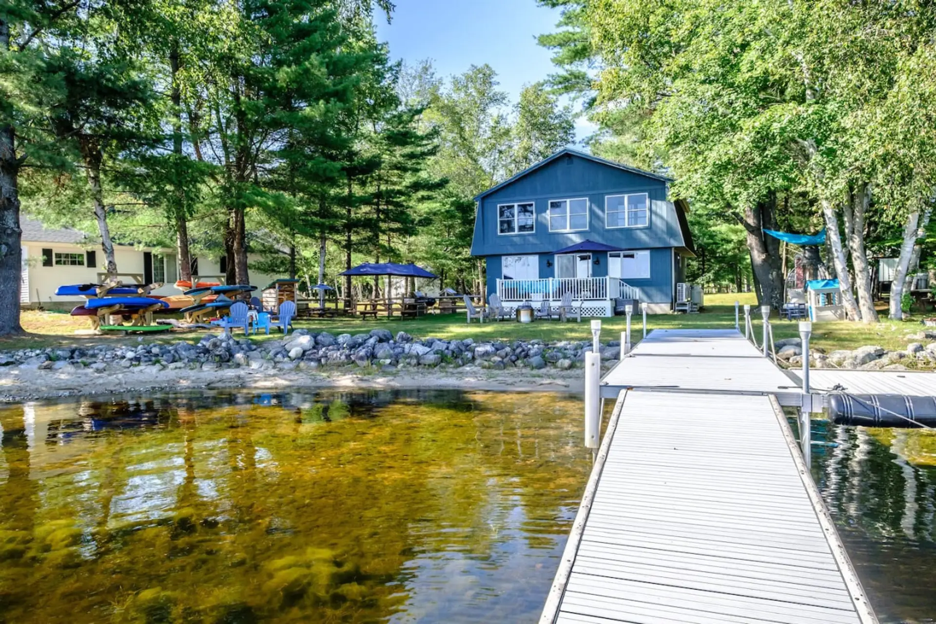 Exterior - Adirondack chairs surrounding a Solo Stove, ample seating with a picnic table and umbrella, gas grill, 1 double kayak , 3 single kayaks, 2 paddleboards, 1 child paddleboard, 1 - peddle boat. There is a private dock for guest use as well!
