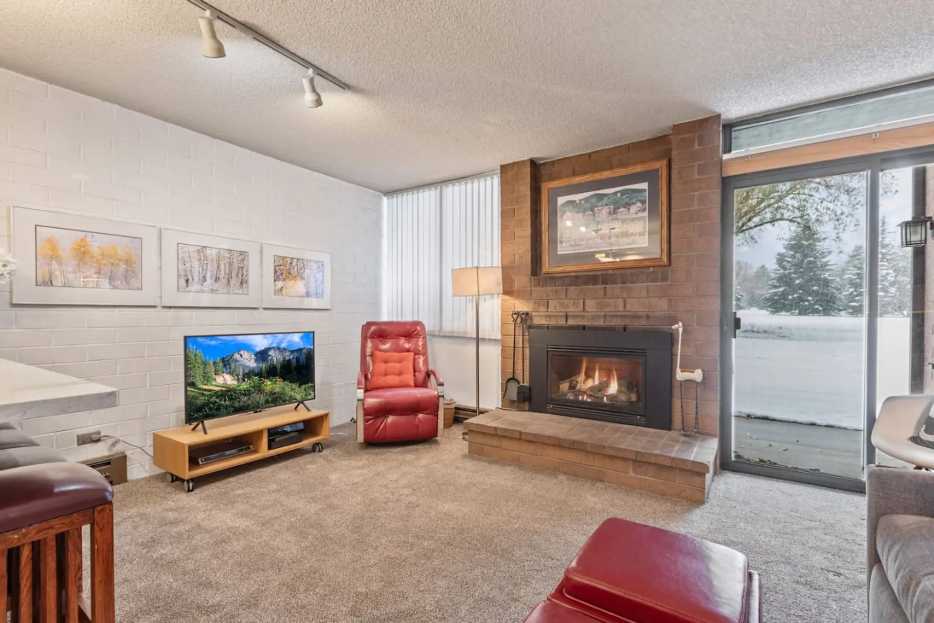 Kick back in the cozy living room featuring a soft couch, flat-screen TV, and a warm gas fireplace – the perfect après-ski setup