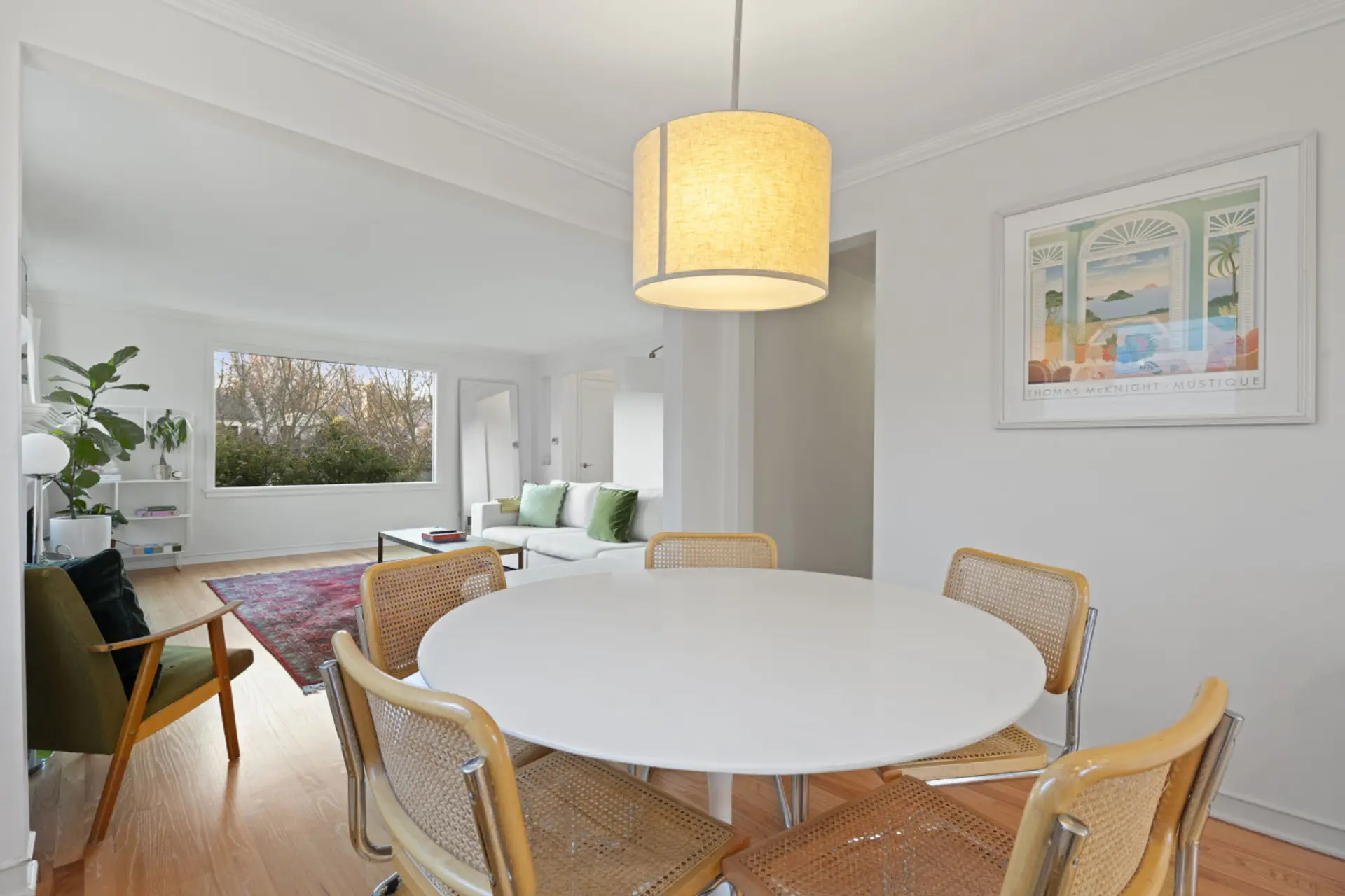 DINING: This bright dining area seats six and includes a high chair for little ones. A cozy pendant light and large windows create a warm, inviting atmosphere.