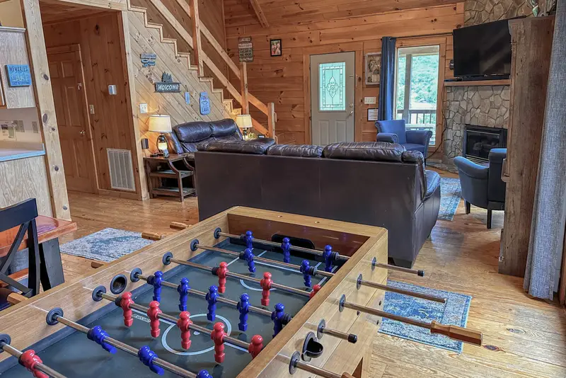 Open living area with foosball table and stairs to the second floor