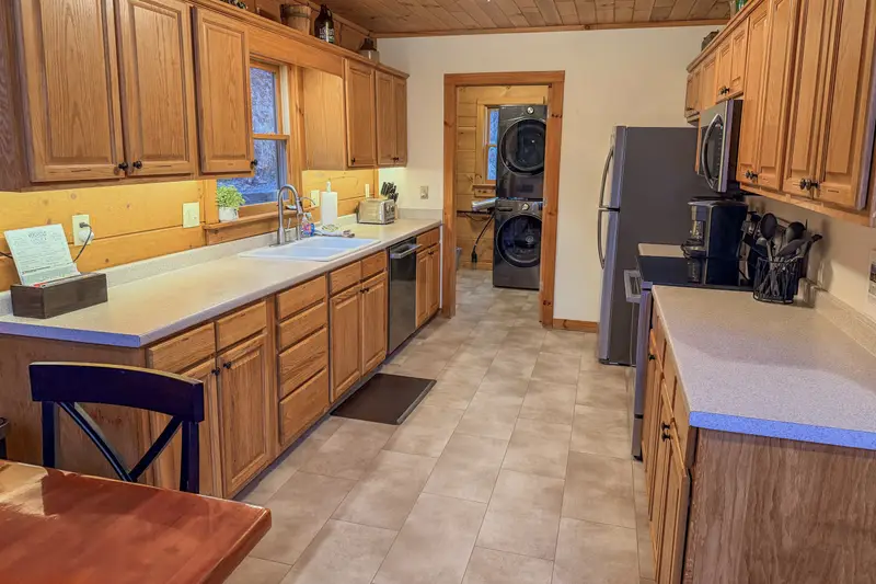 Fully stocked kitchen with new stainless appliances and laundry nook