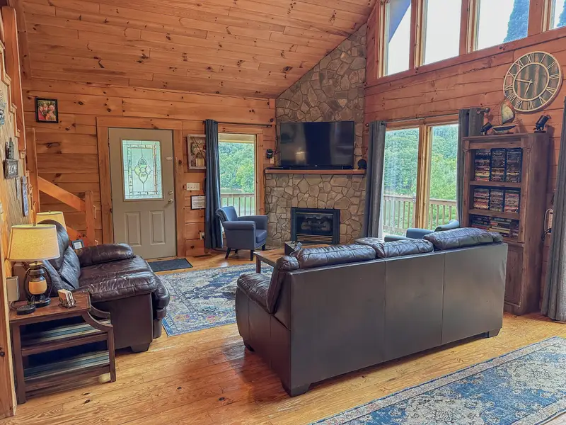 Living room with a stone gas fireplace and leather seating
