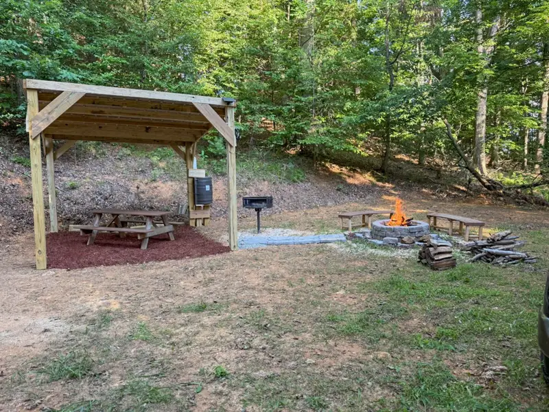 The private Nature Retreat with covered picnic shelter, charcoal grill, and fire pit