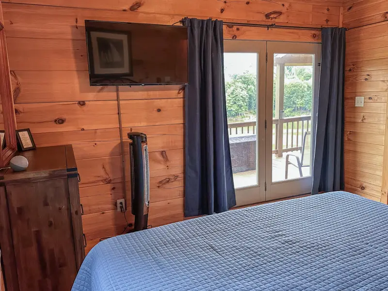 Primary bedroom with direct deck access and 180-degree lake views
