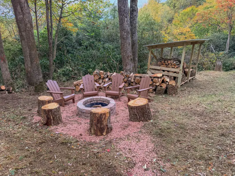 Outdoor fire pit with Adirondack chairs and log seating