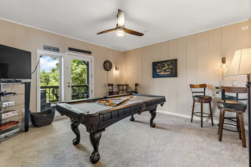 Lower-level game room with pool table, darts, and bar seating