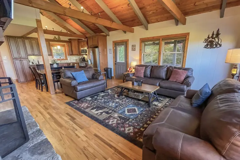 Open living room with exposed beams and leather seating