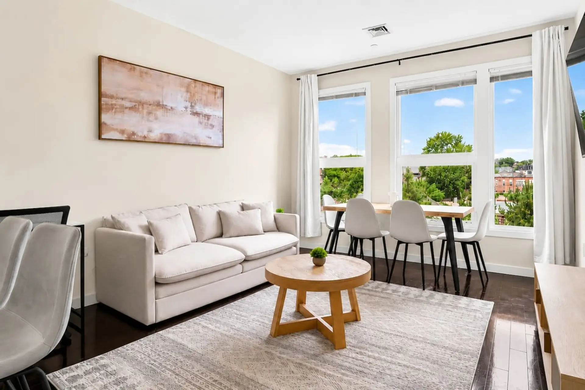 Bright living room with large windows, dining area and plenty of natural light.