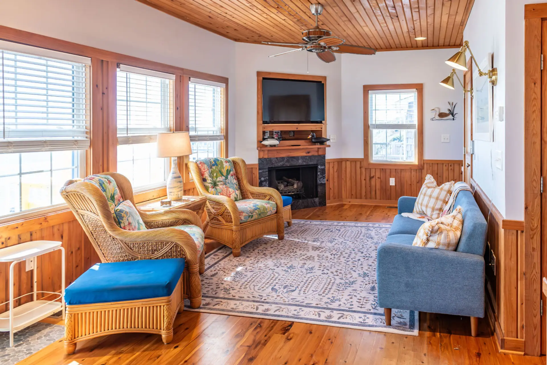 Bright coastal living room with large windows, cozy seating, and natural light—ideal for relaxing after a beach day