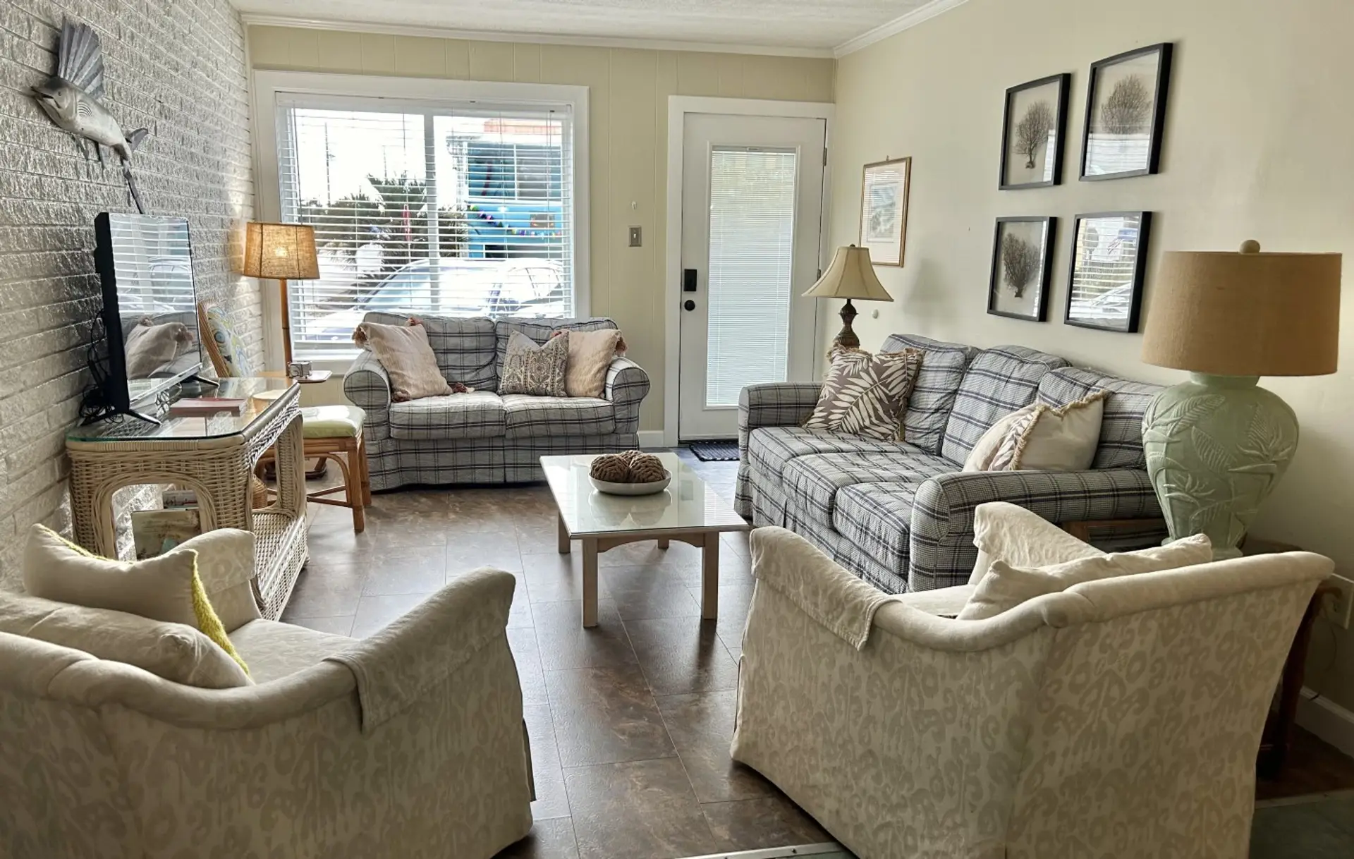 Relax in this cozy living room featuring comfortable seating, coastal-inspired décor, and plenty of natural light