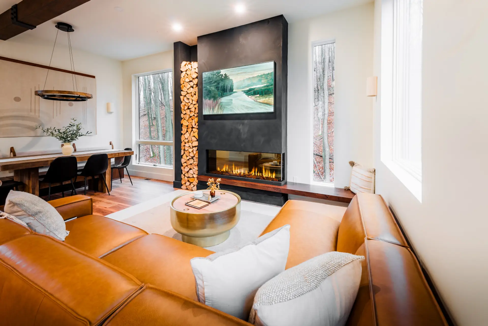 the living room features an electric fireplace, frame TV, castlery leather couch and amazing views of the glacial hills.