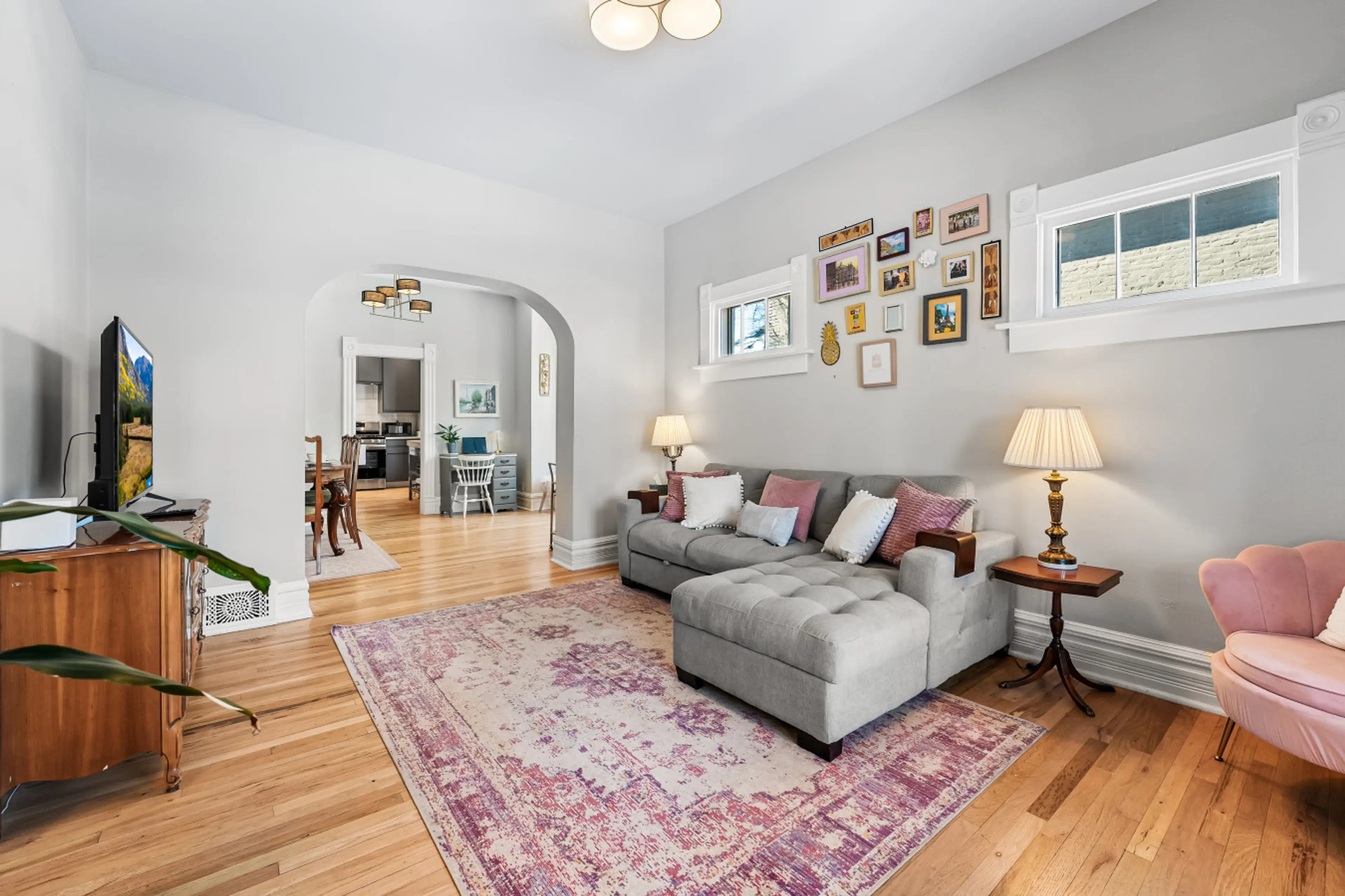 The Living room has comfortable seating, natural light, plants, and the couch doubles as a bed!