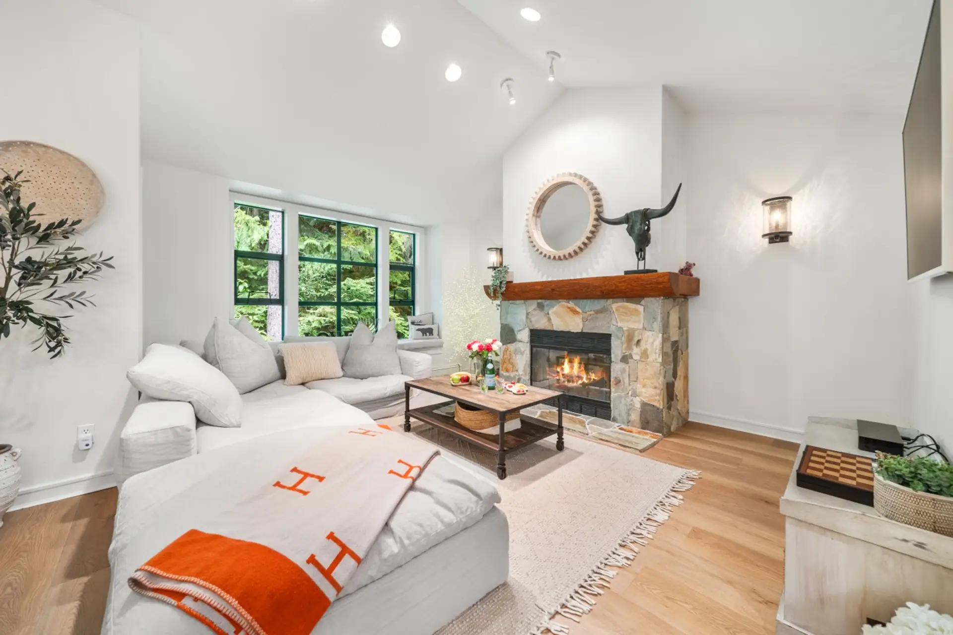 Spacious living room with forest views and a Samsung Frame 4K QLED Smart TV.
