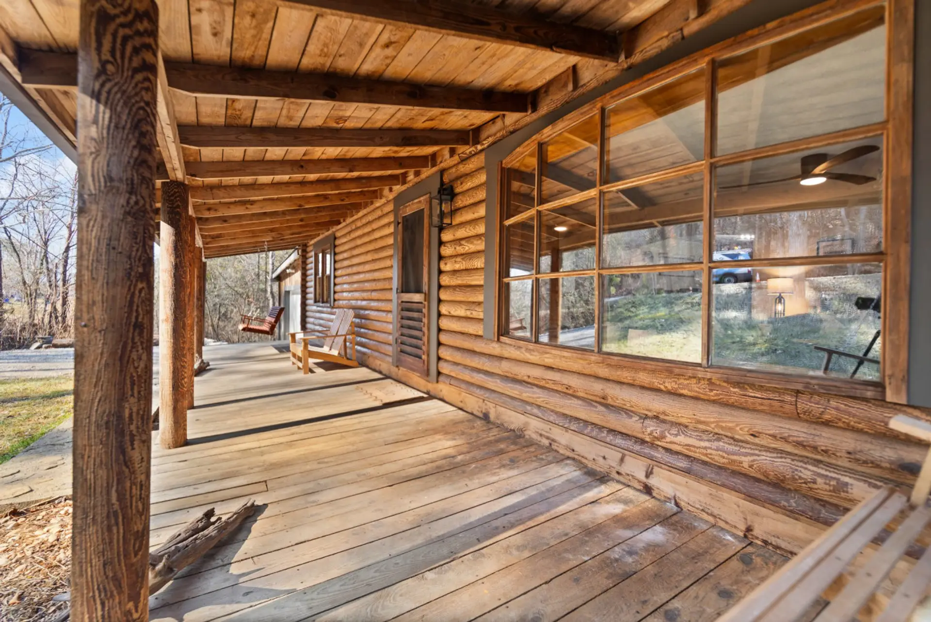 Rustic charm meets relaxation – unwind on this cozy cedar cabin porch, surrounded by nature and timeless craftsmanship.