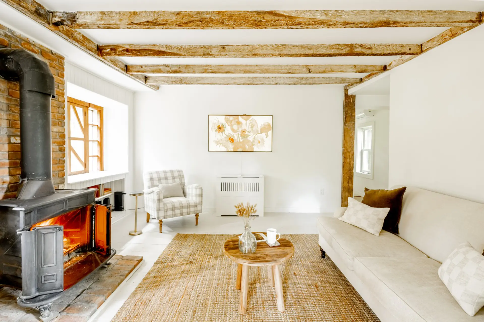 Living Room: Bright space with rustic beams, a warm stove, and inviting seating for relaxation!