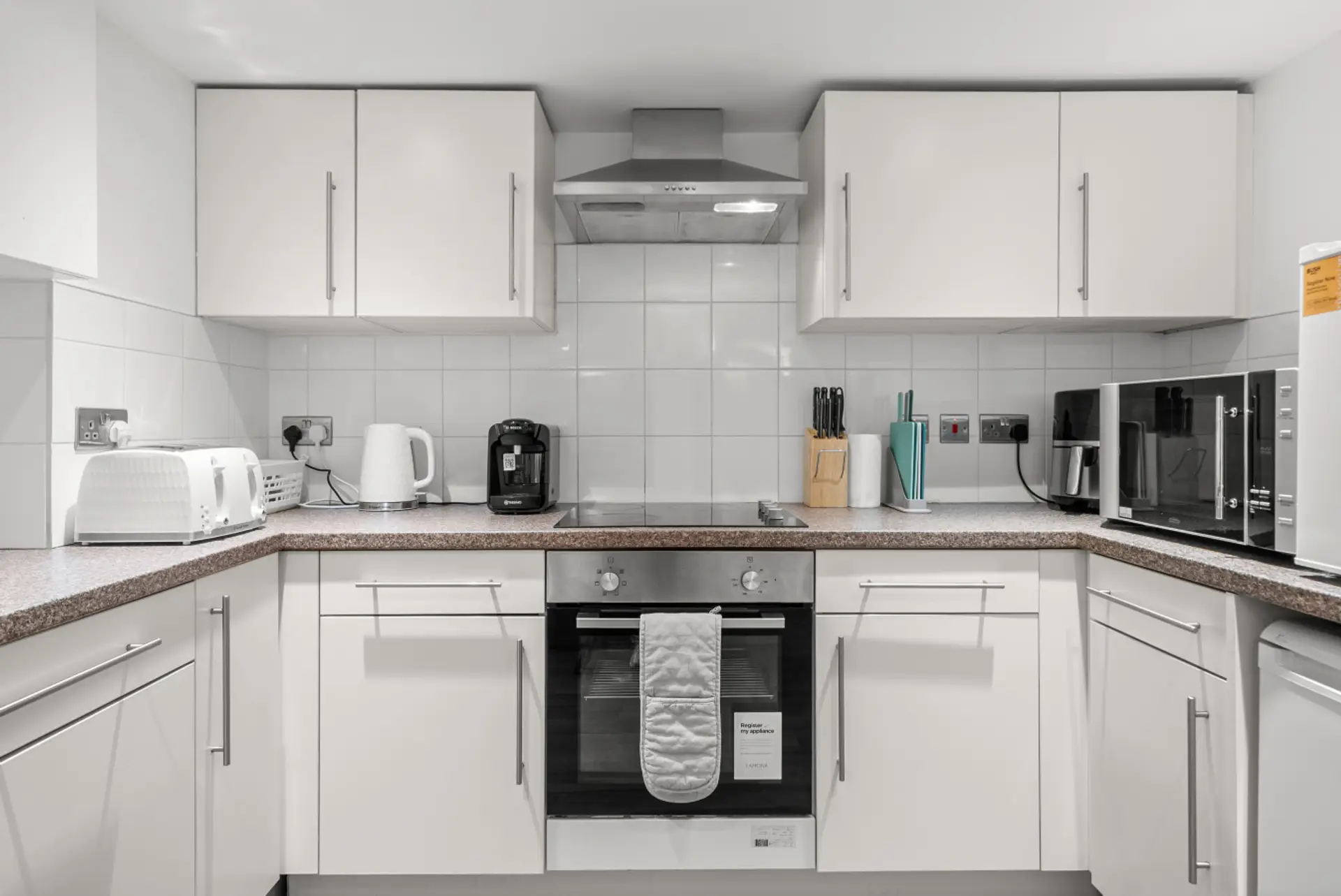 Shared kitchen with oven and hob located in the basement, suitable for preparing home-cooked meals.