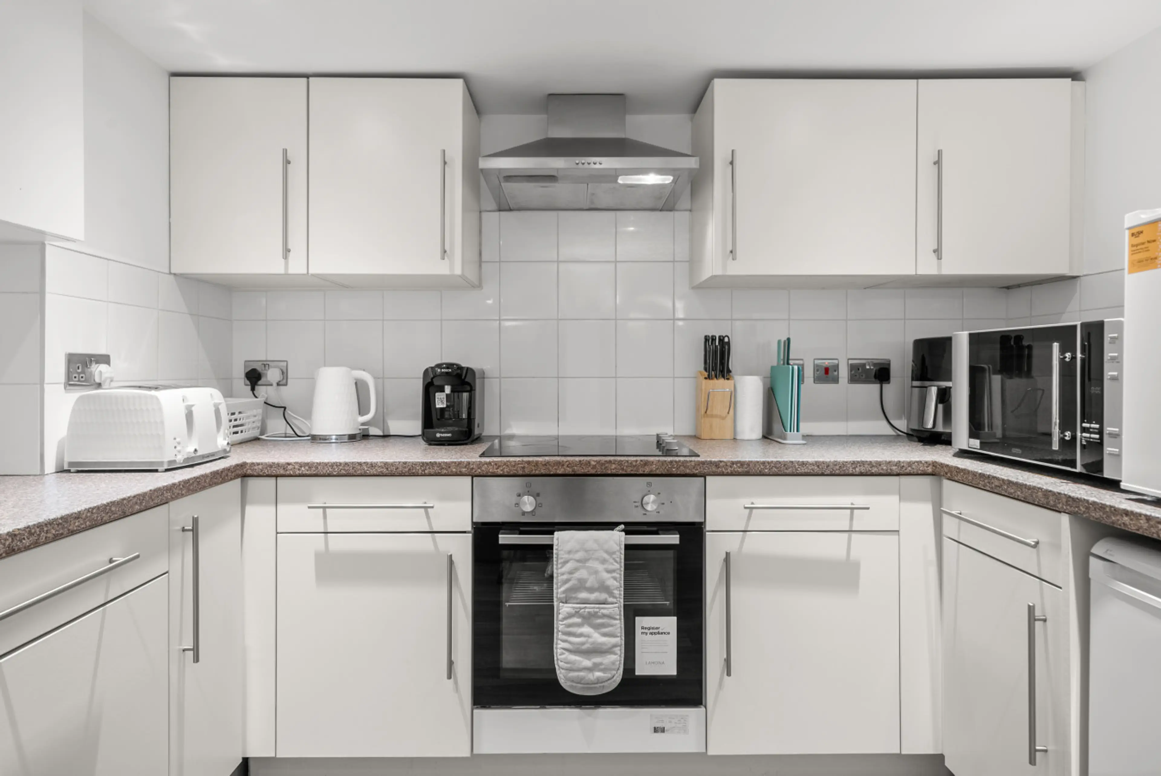 Shared kitchen with oven and hob located in the basement, suitable for preparing home-cooked meals.