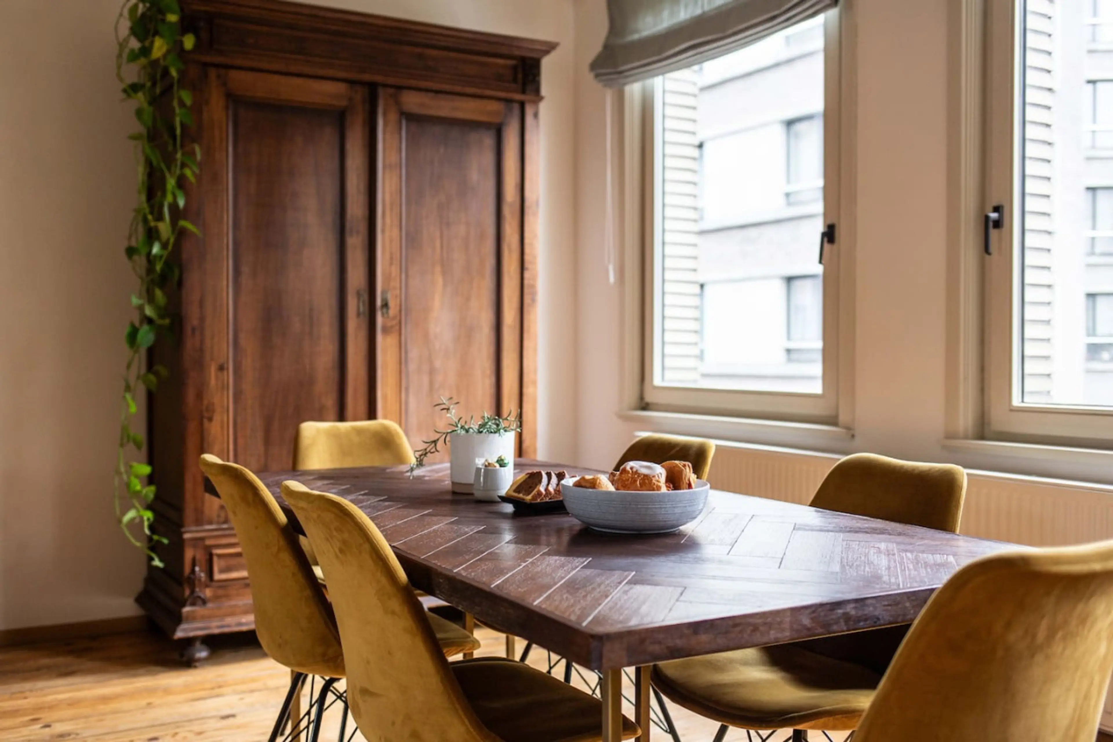 Warm dining space w/ wooden table & cushioned chairs, ideal for shared meals & conversation