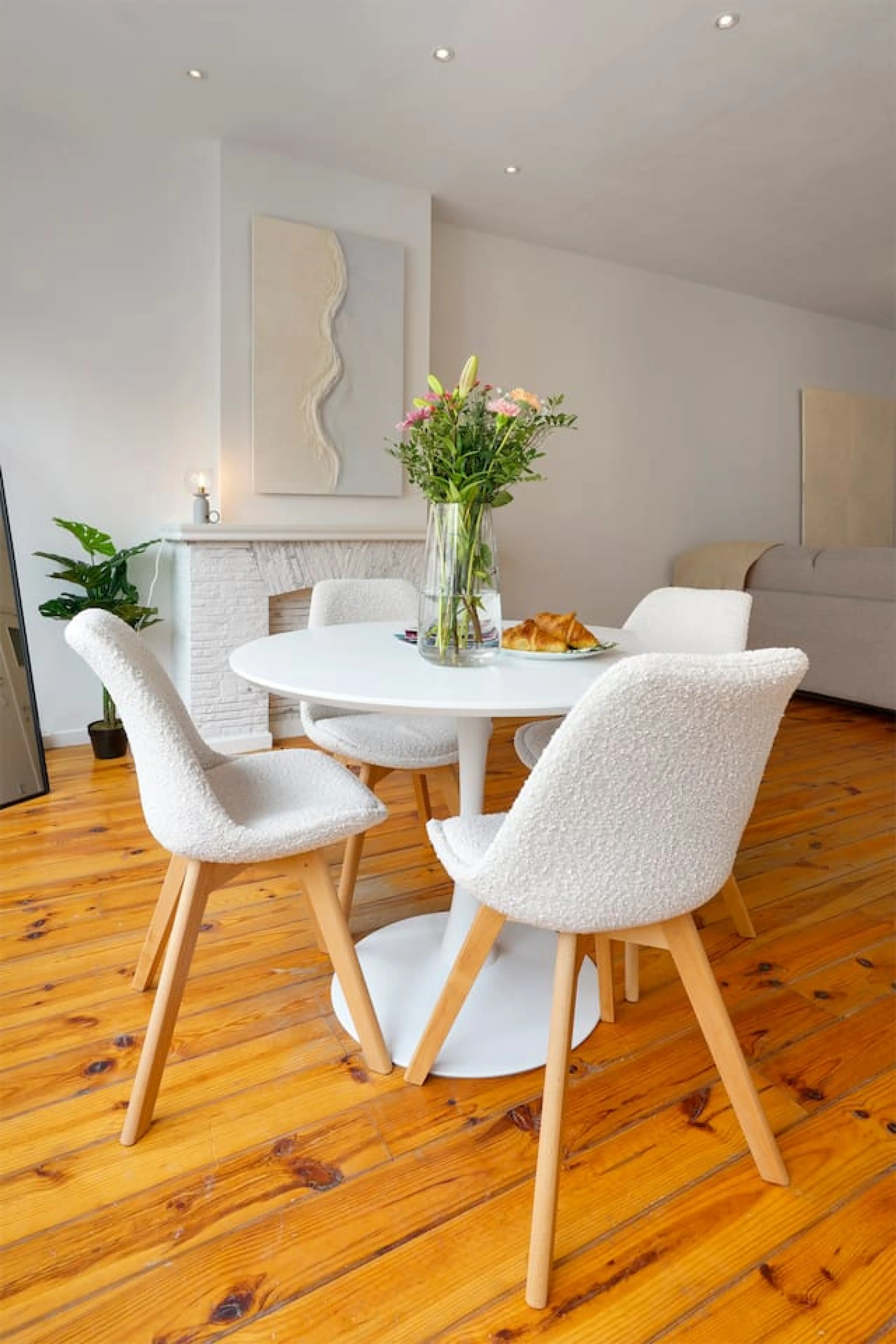 Cozy dining nook w/ round table, soft chairs & fresh flowers for relaxed meals together