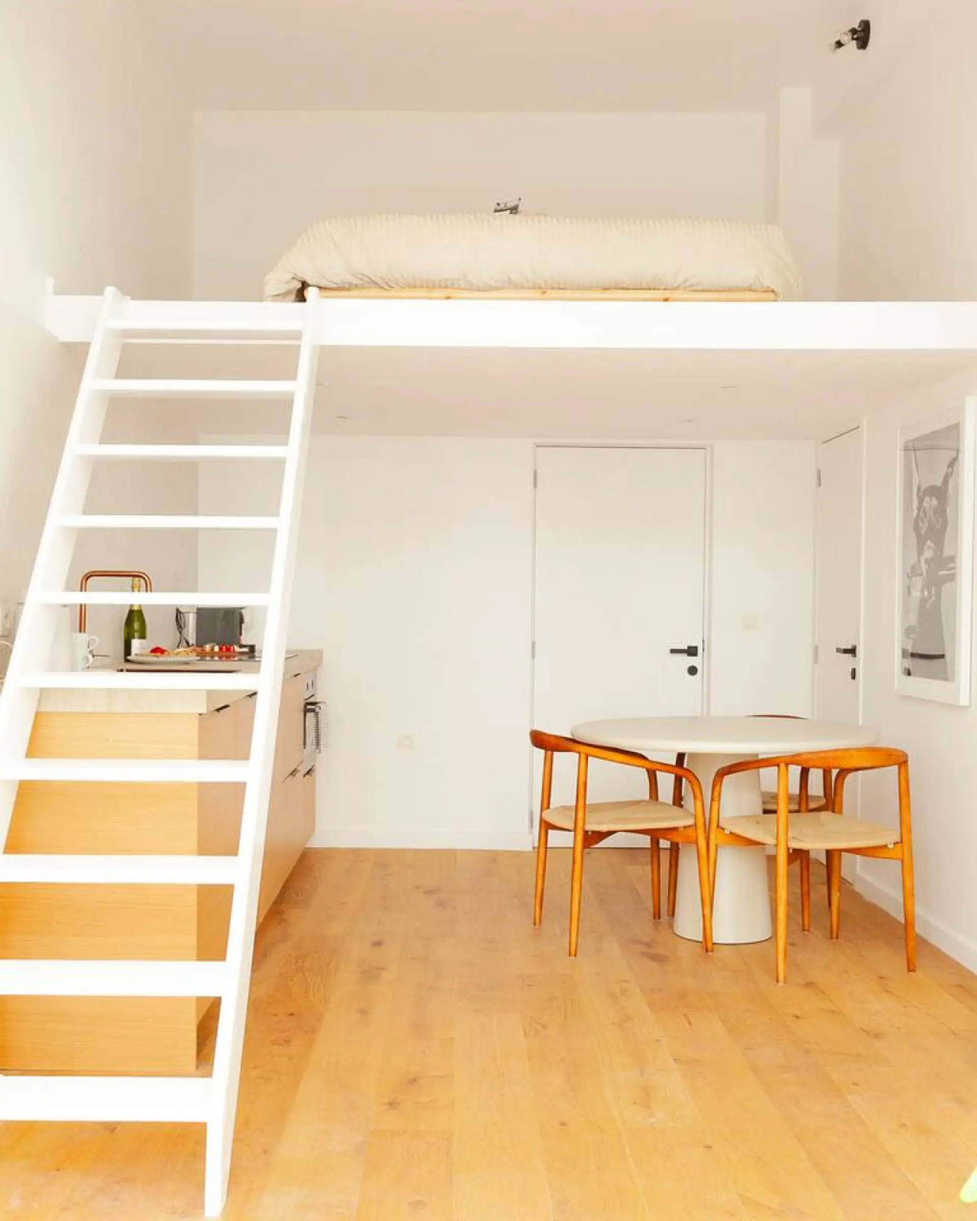 Loft-style space w/ ladder access & dining area tucked below in a bright layout