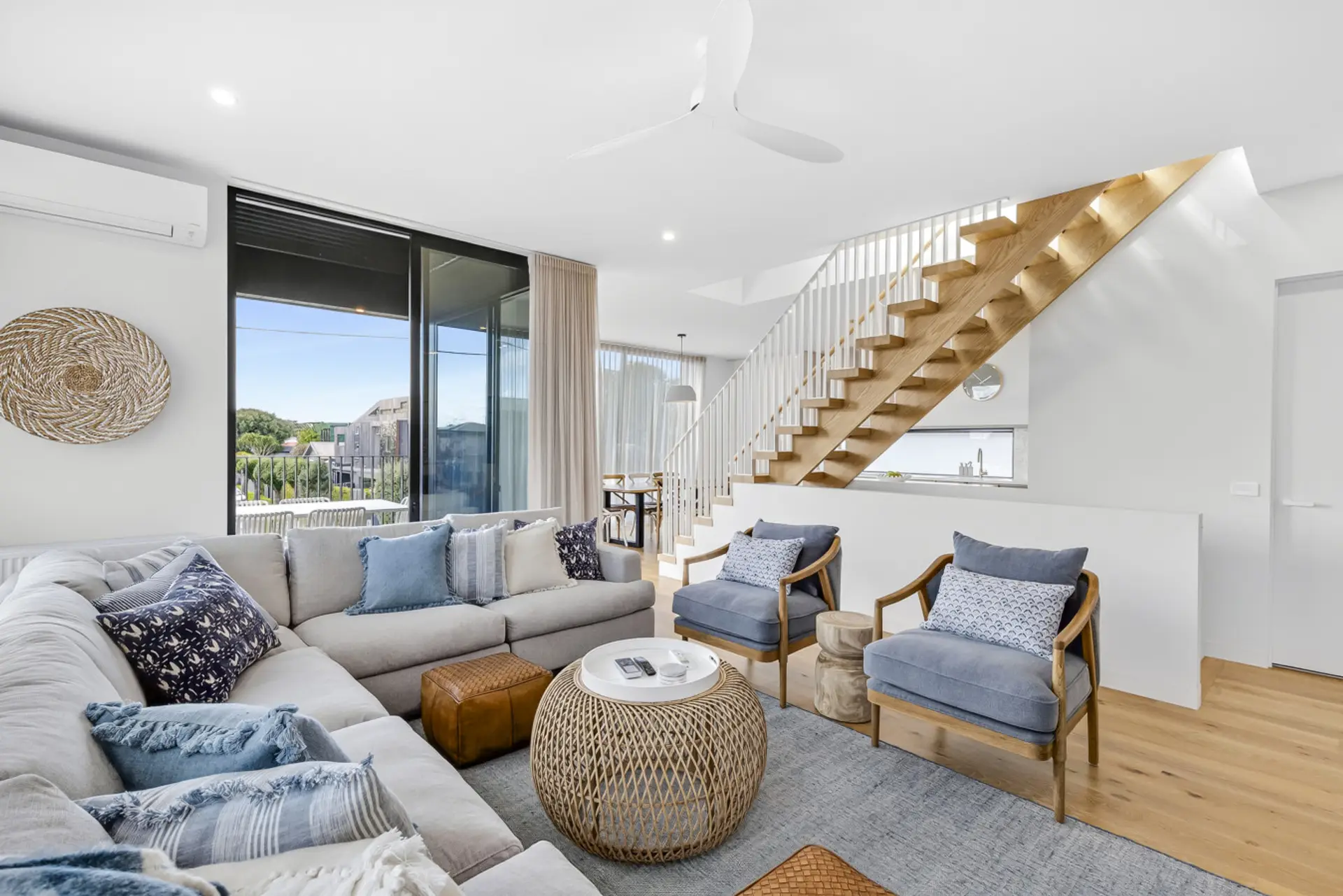 Open-plan living with stylish seating and striking timber staircase