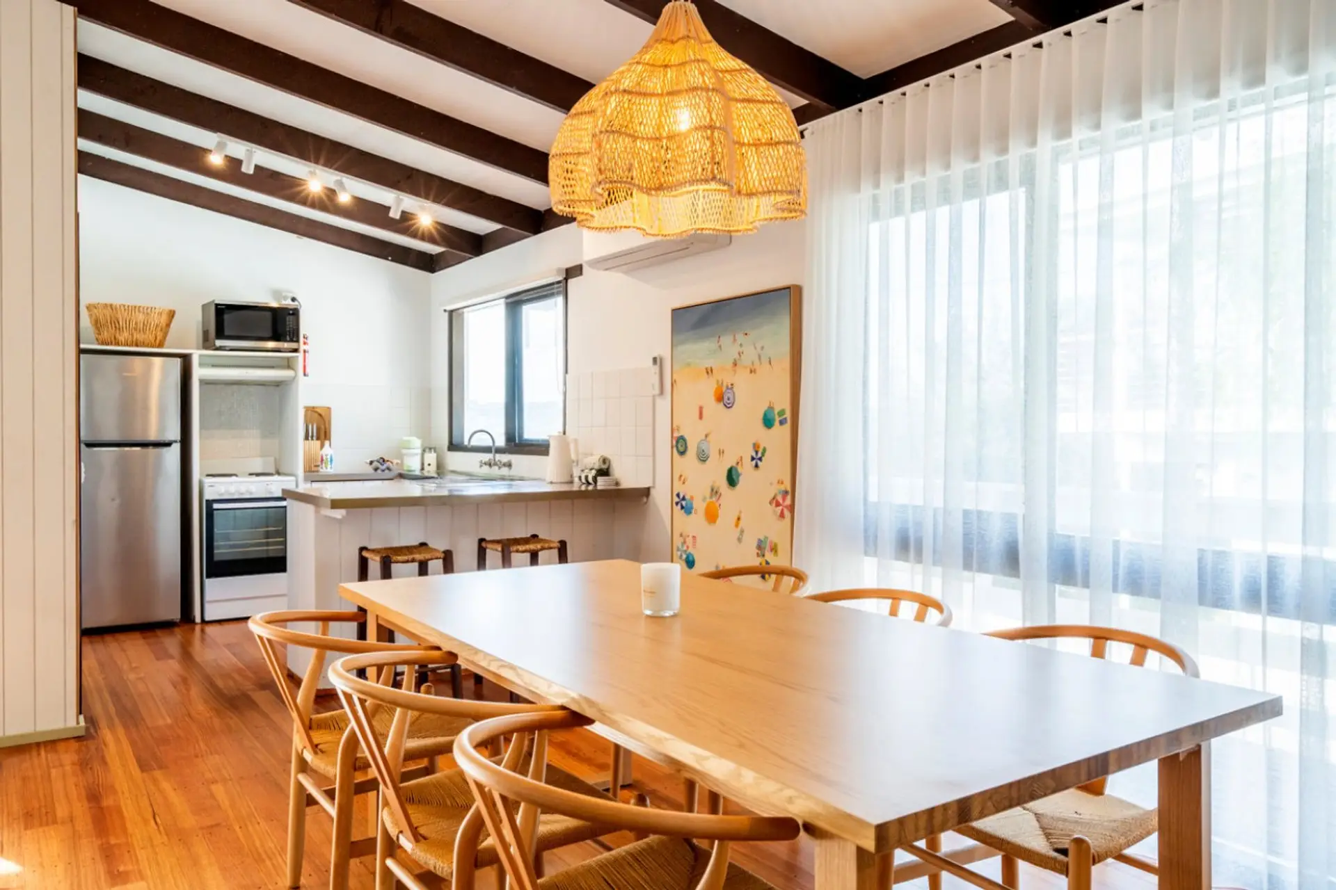 Open-plan kitchen and dining area with timber finishes, modern appliances, and seating for family meals