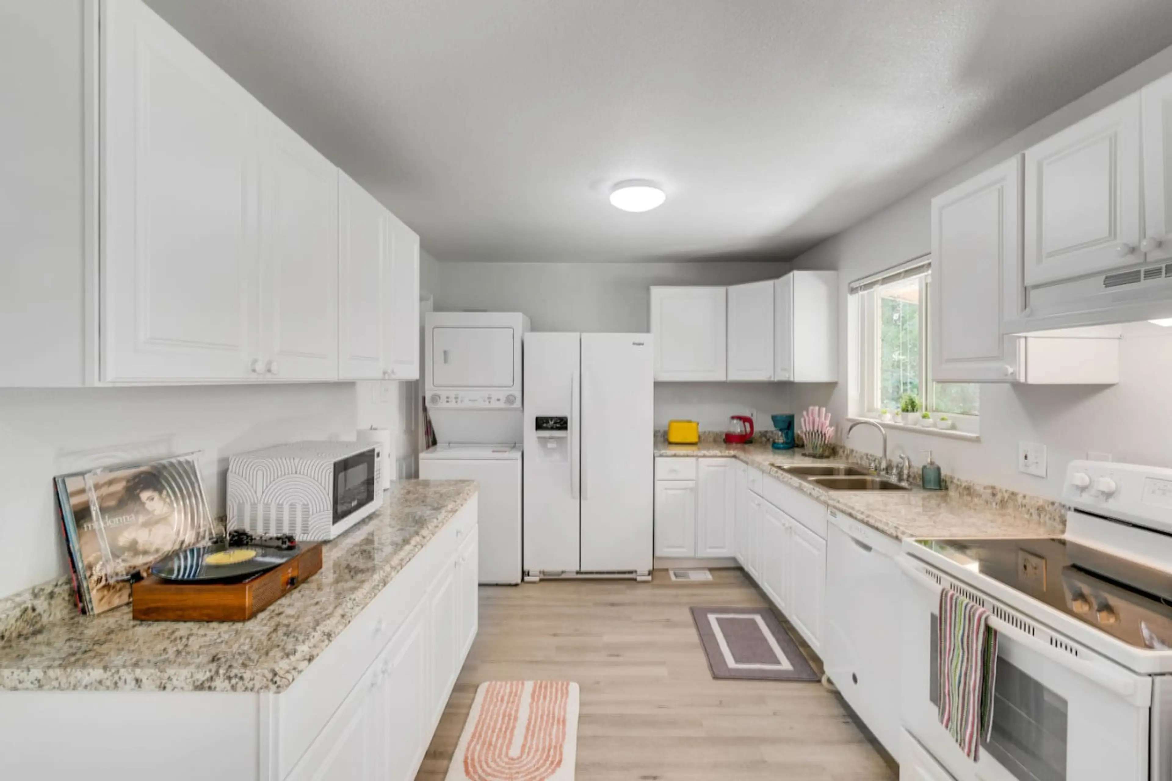 This kitchen is adorned with white cabinets and appliances. A space where every meal becomes a masterpiece