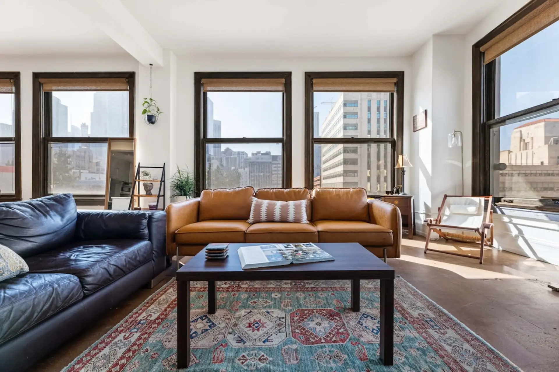 Enjoy natural sunlight in this beautifully designed living area, featuring comfy seating and vibrant city views. The couches can also accommodate two additional guests for a cozy stay.