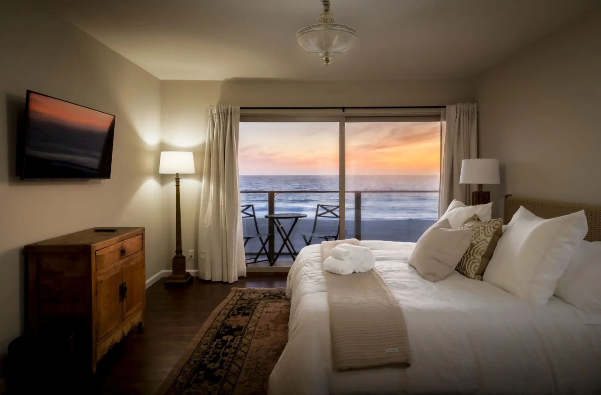 Wake up in a plush king-size bed to endless ocean views from this serene, sunlit bedroom retreat.