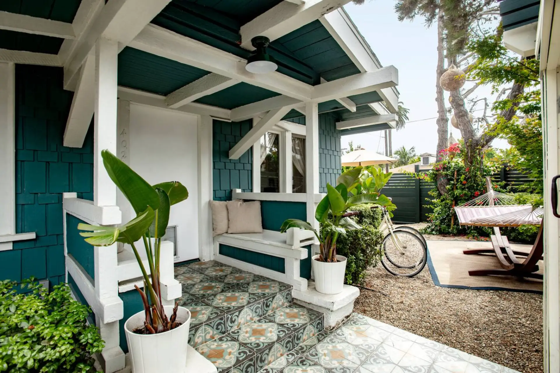 This cozy coastal nook blends vintage tile, beach cruiser vibes, and hammock dreams into your perfect seaside escape.