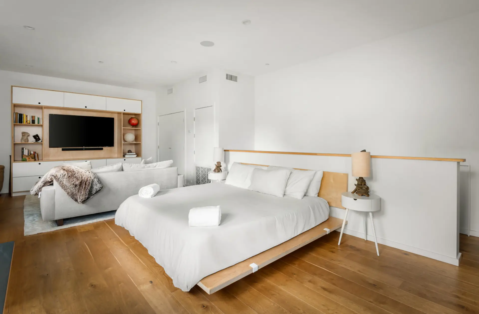 Your versatile retreat with a small workspace, comfy sofa, TV, and bedroom area.