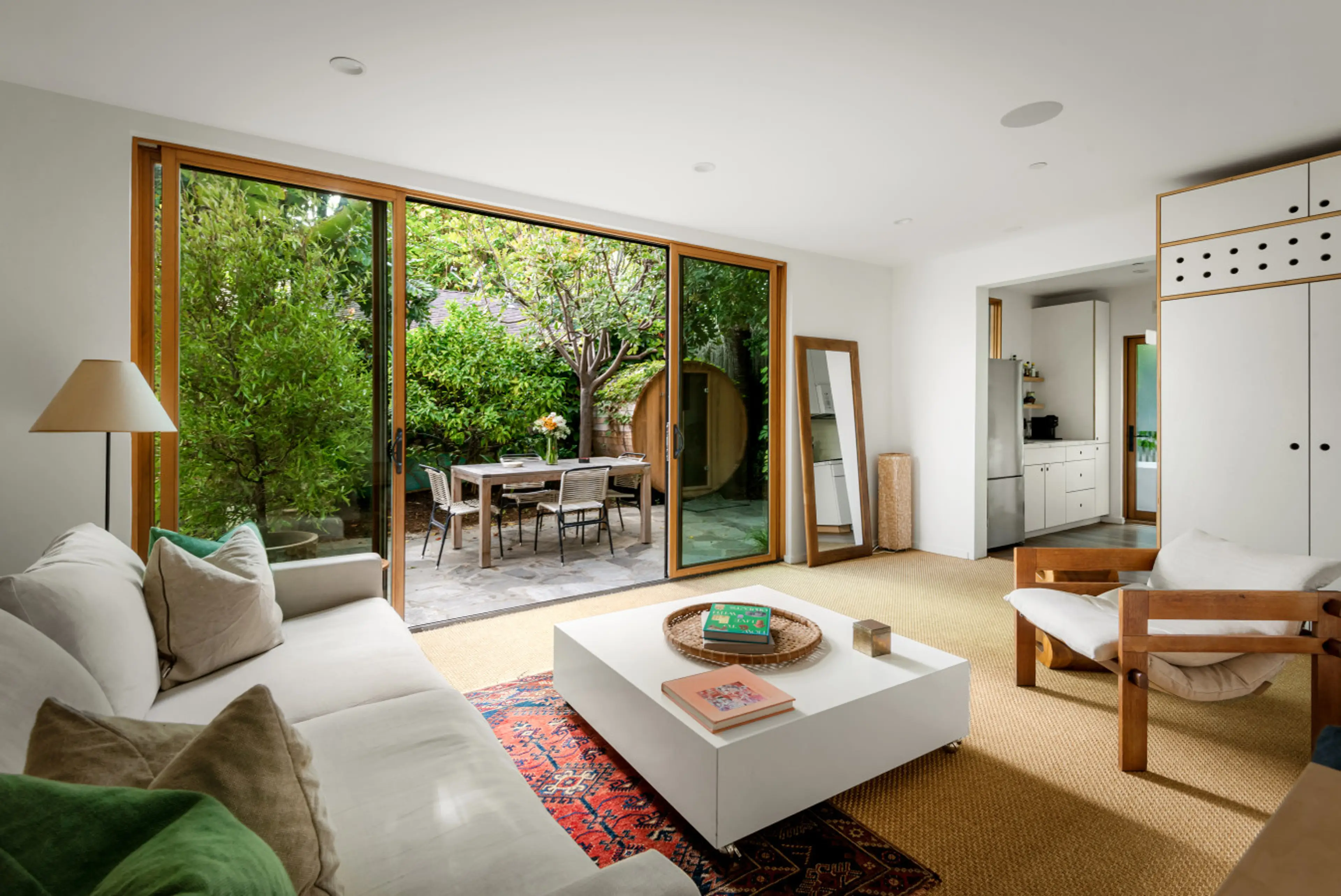 Relax in the living room while enjoying a refreshing view of lush greenery outside.